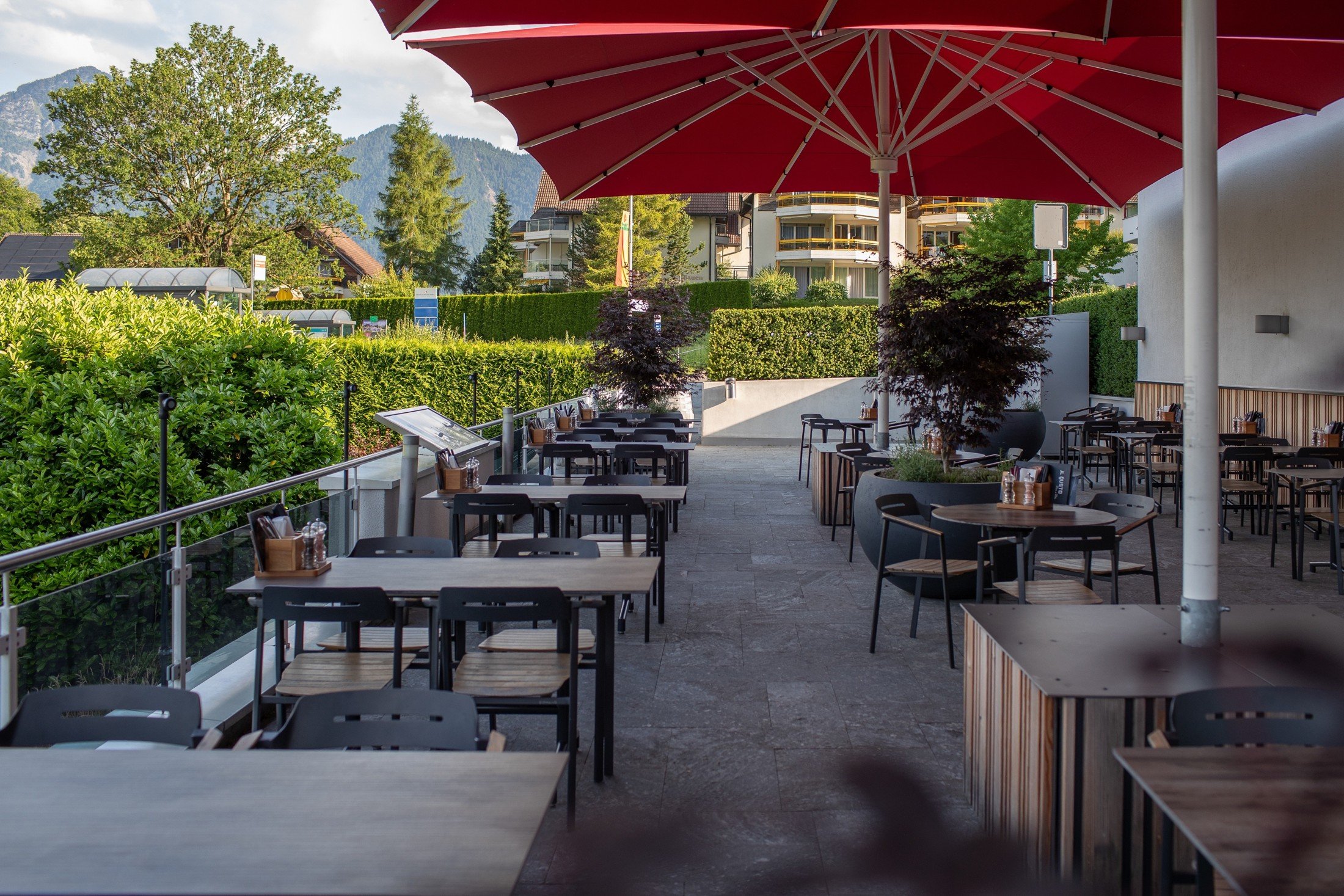 Panorama Restaurant terrace with outdoor dining furniture beneath red parasols.