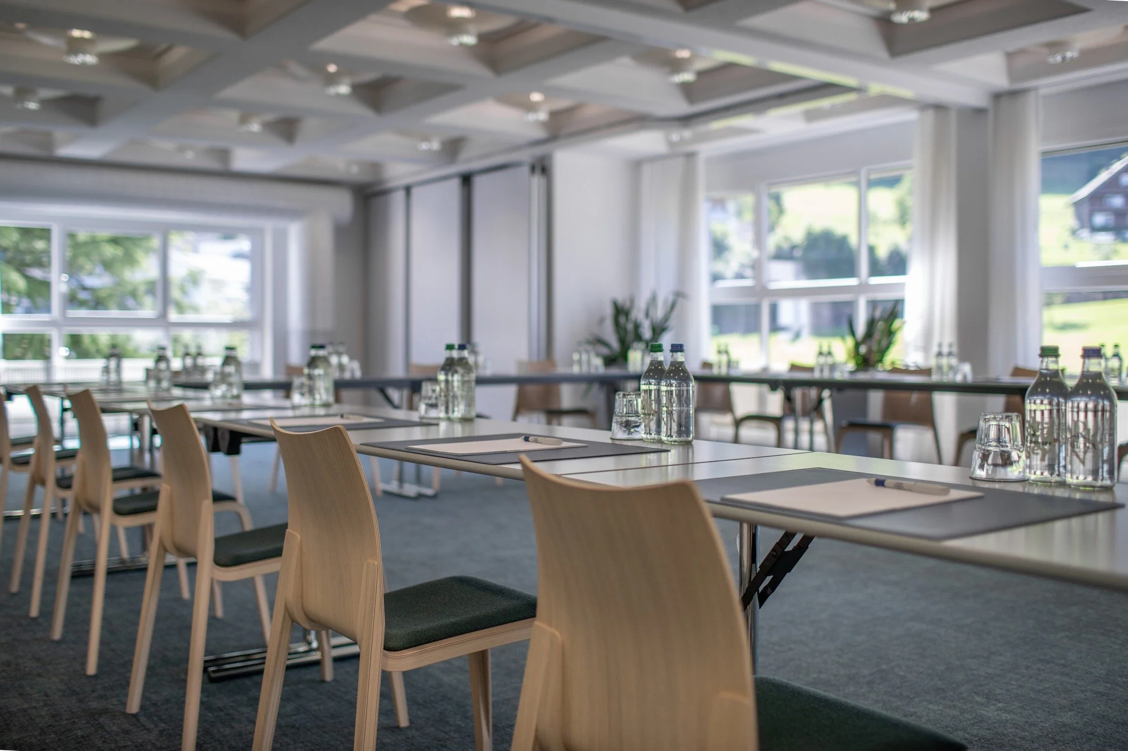 Swiss Holiday Park conference room with timber chairs, meeting tables and large windows overlooking greenery.