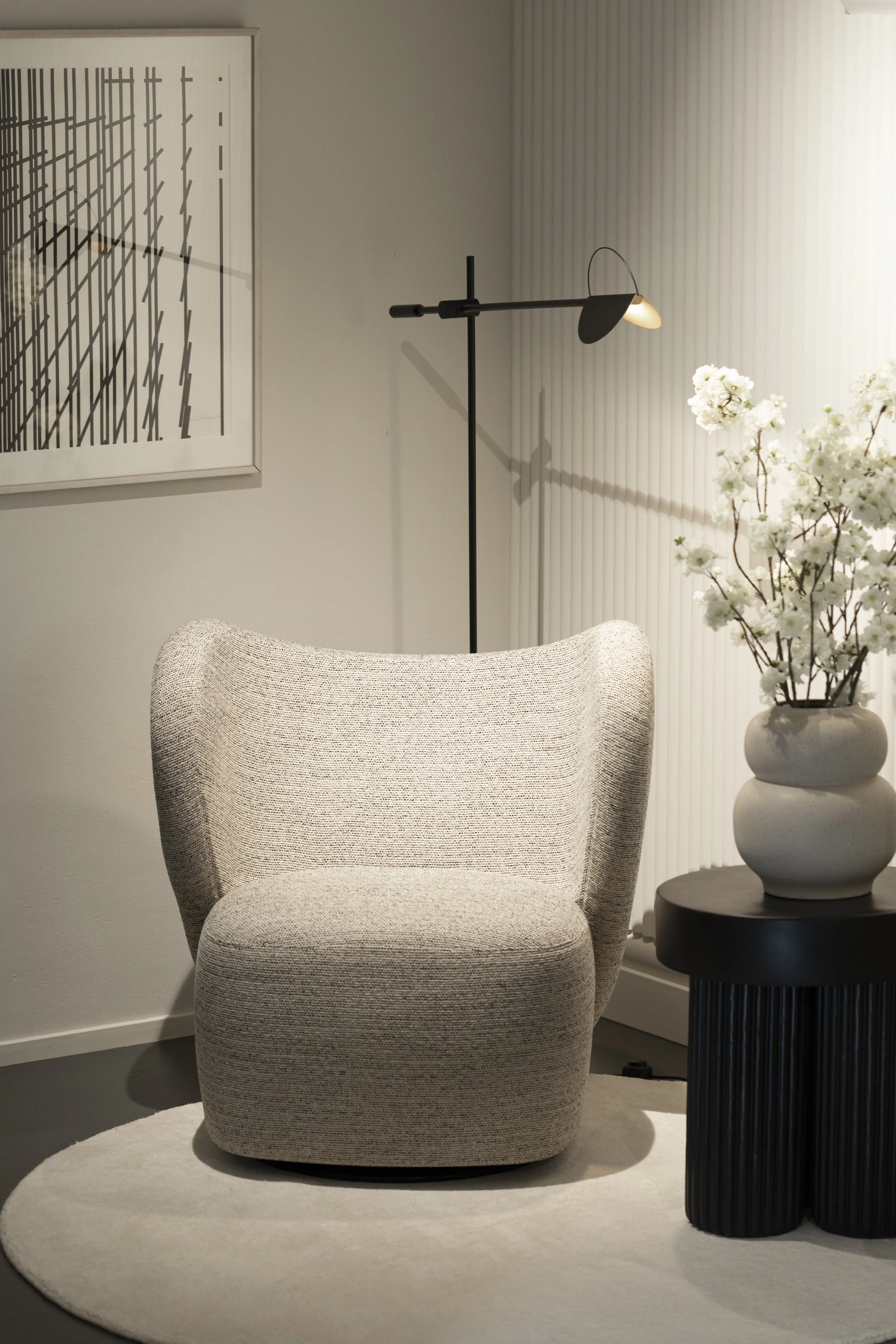 Upholstered lounge chair, sculptural lighting and flowers in the GRESET REICH showroom in Zurich