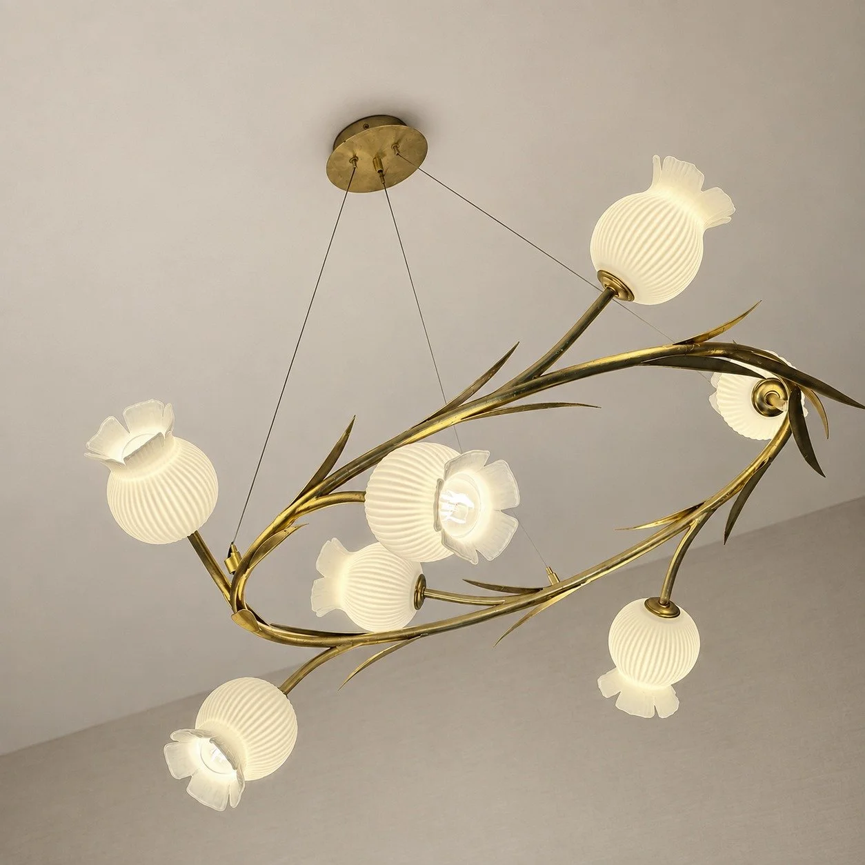 Branch-inspired ceiling light with pale glass shades in a renovated Waldhaus Sils guest room.