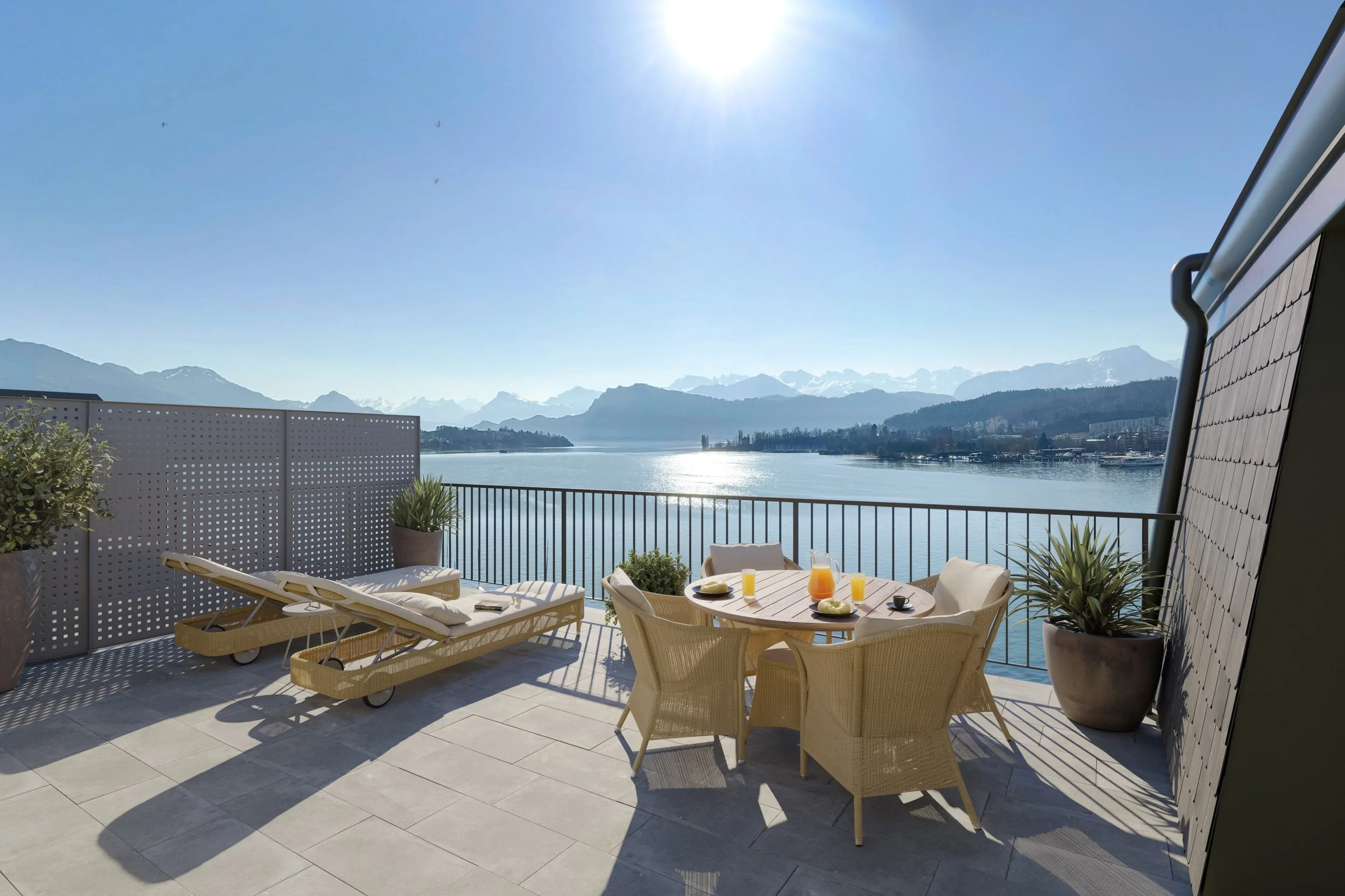 Hotel terrace dining area overlooking Lake Lucerne and the surrounding mountains.