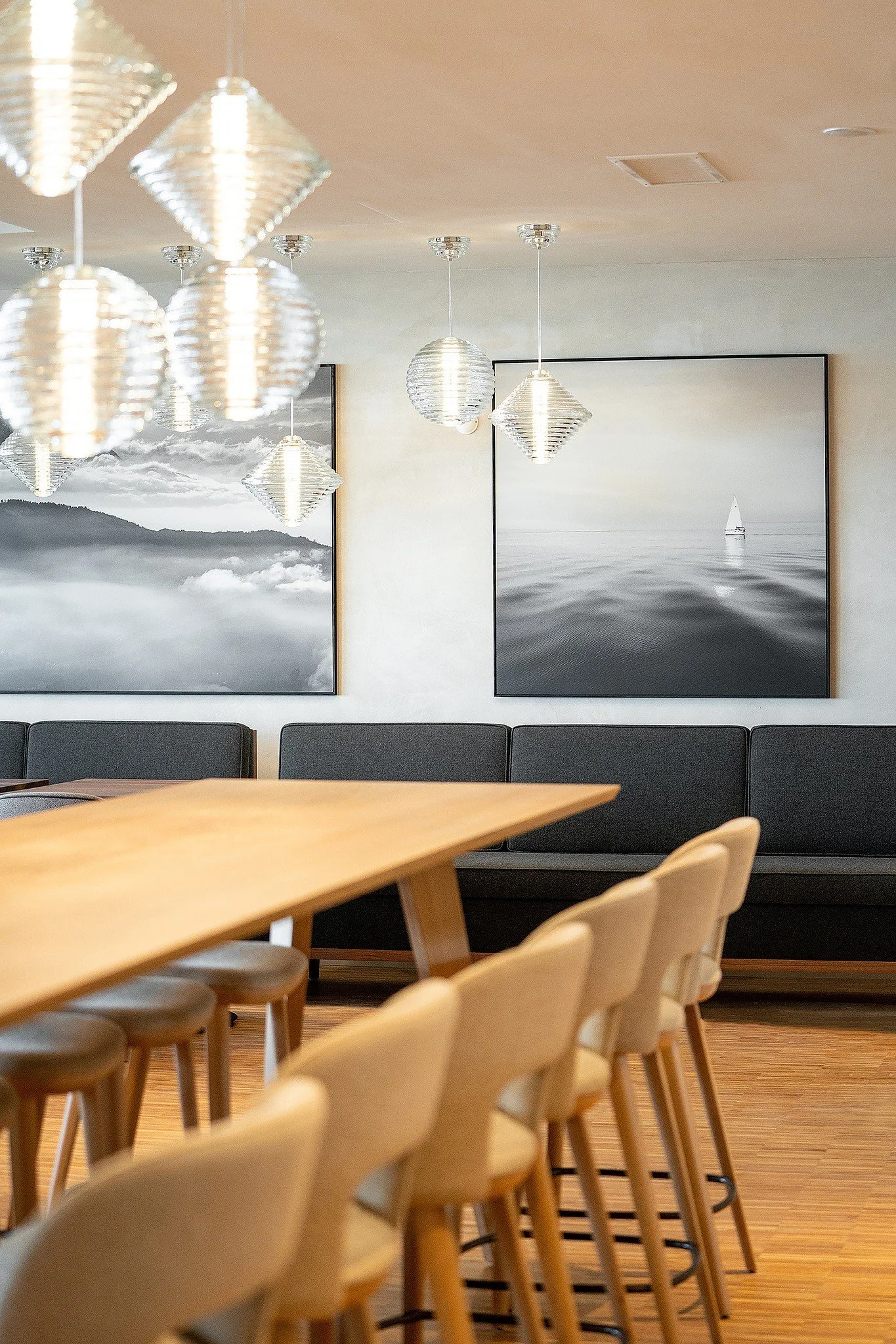 Restaurant dining area with timber tables, upholstered seating and framed landscape artwork.