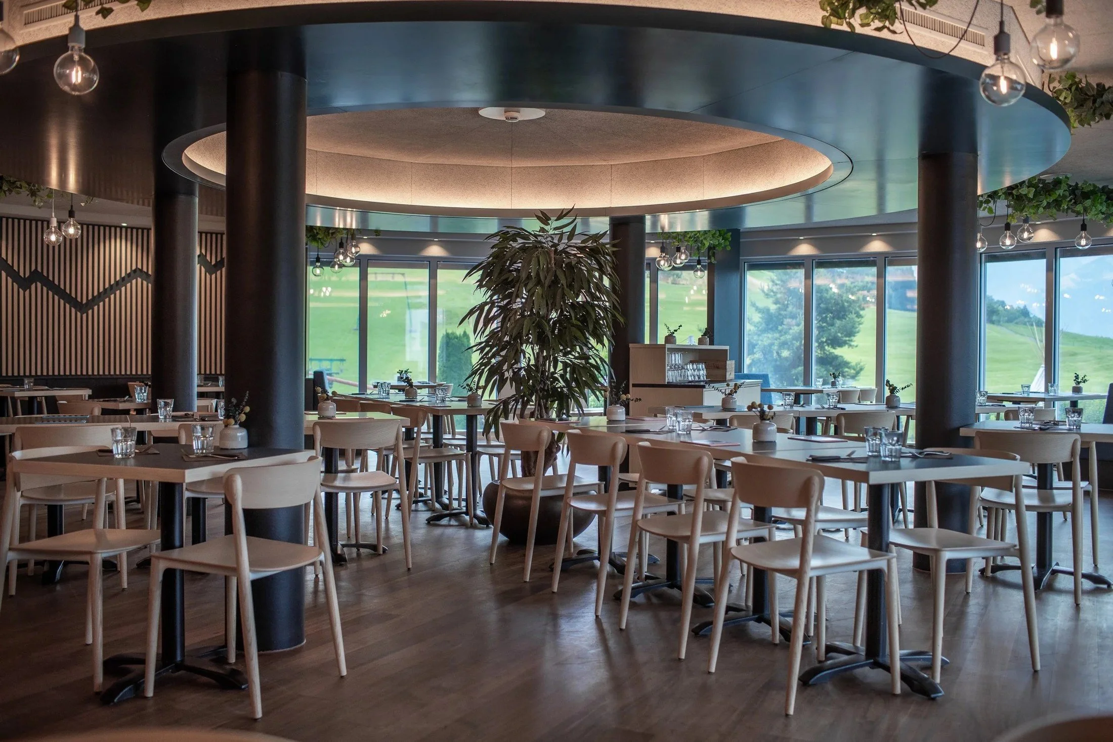 Panorama Restaurant dining area at Swiss Holiday Park with timber chairs, round ceiling features and broad windows.