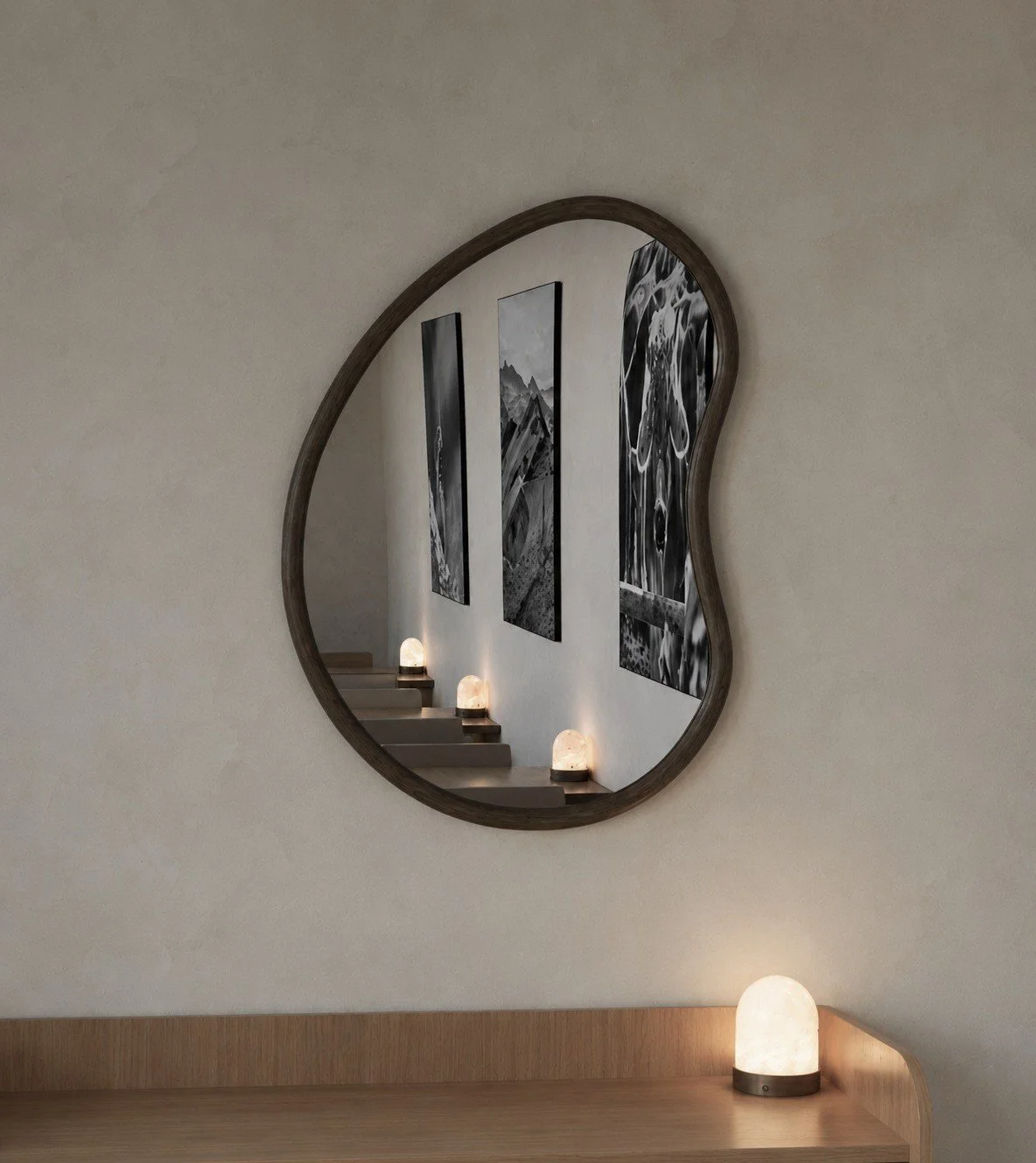 Decorative rounded wall mirror and a small lamp in a Hotel Heiden interior.