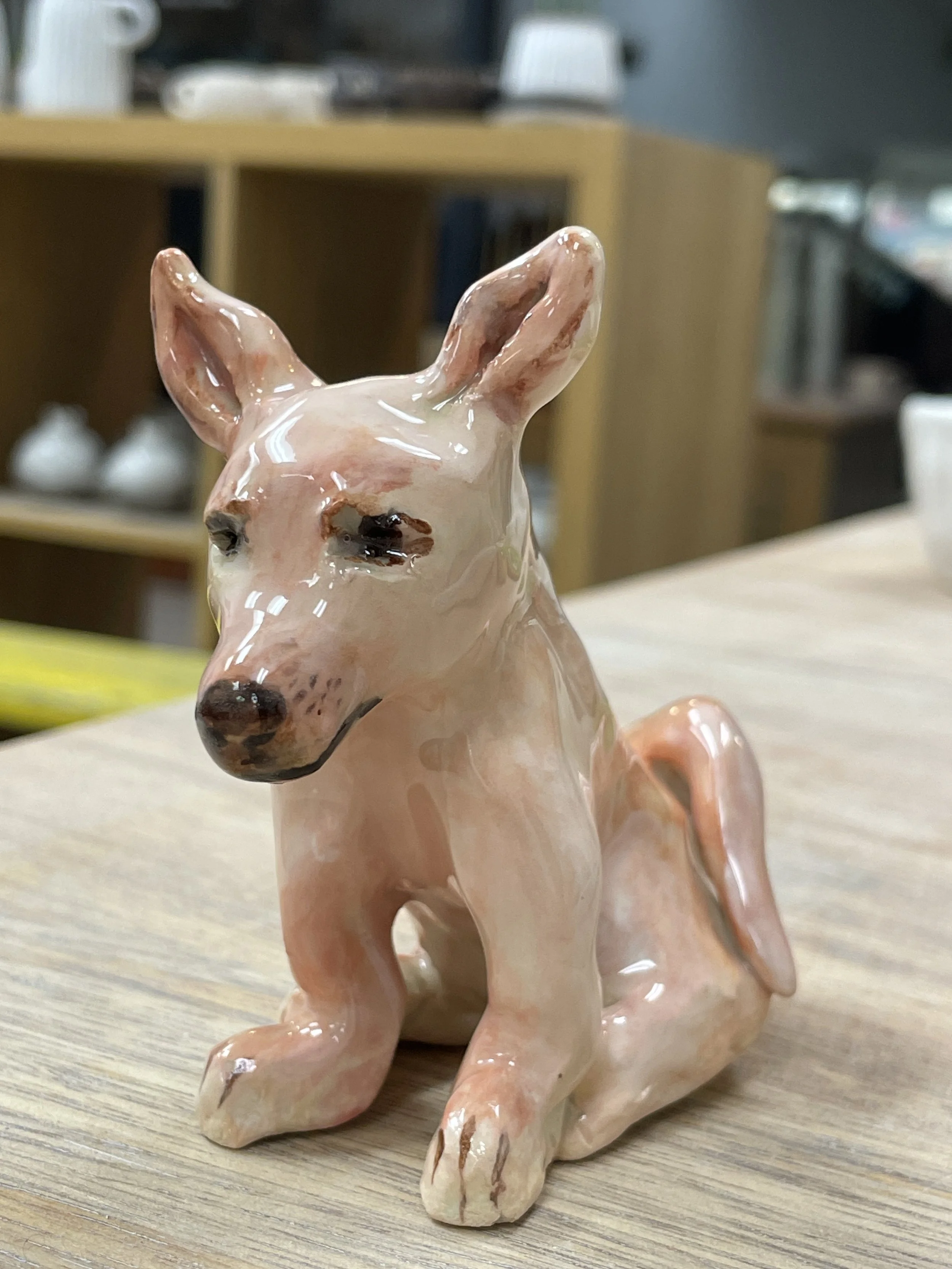 Ceramic dog figurine on wooden surface