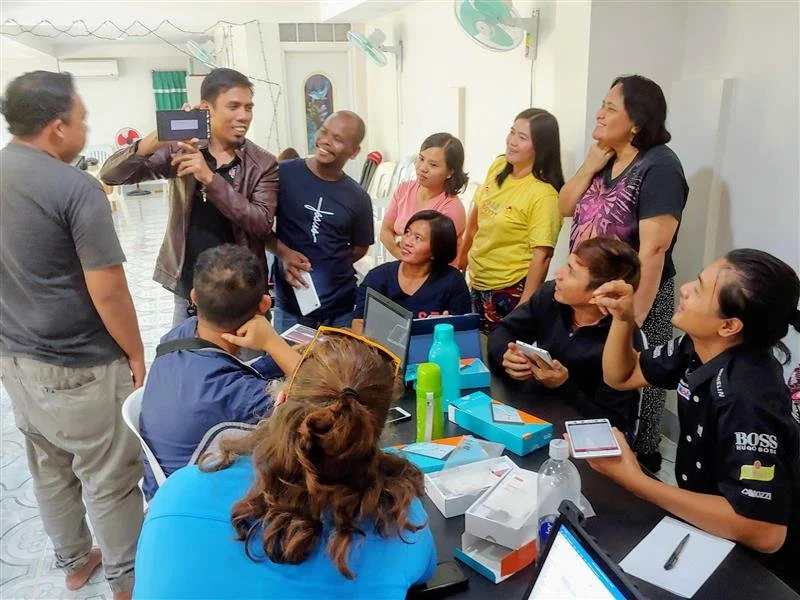 facilitator showing off device at event