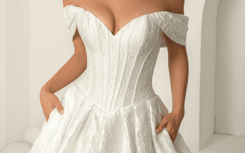 Off-the-shoulder corset ball gown with textured fabric reflecting 2026 wedding dress trends.