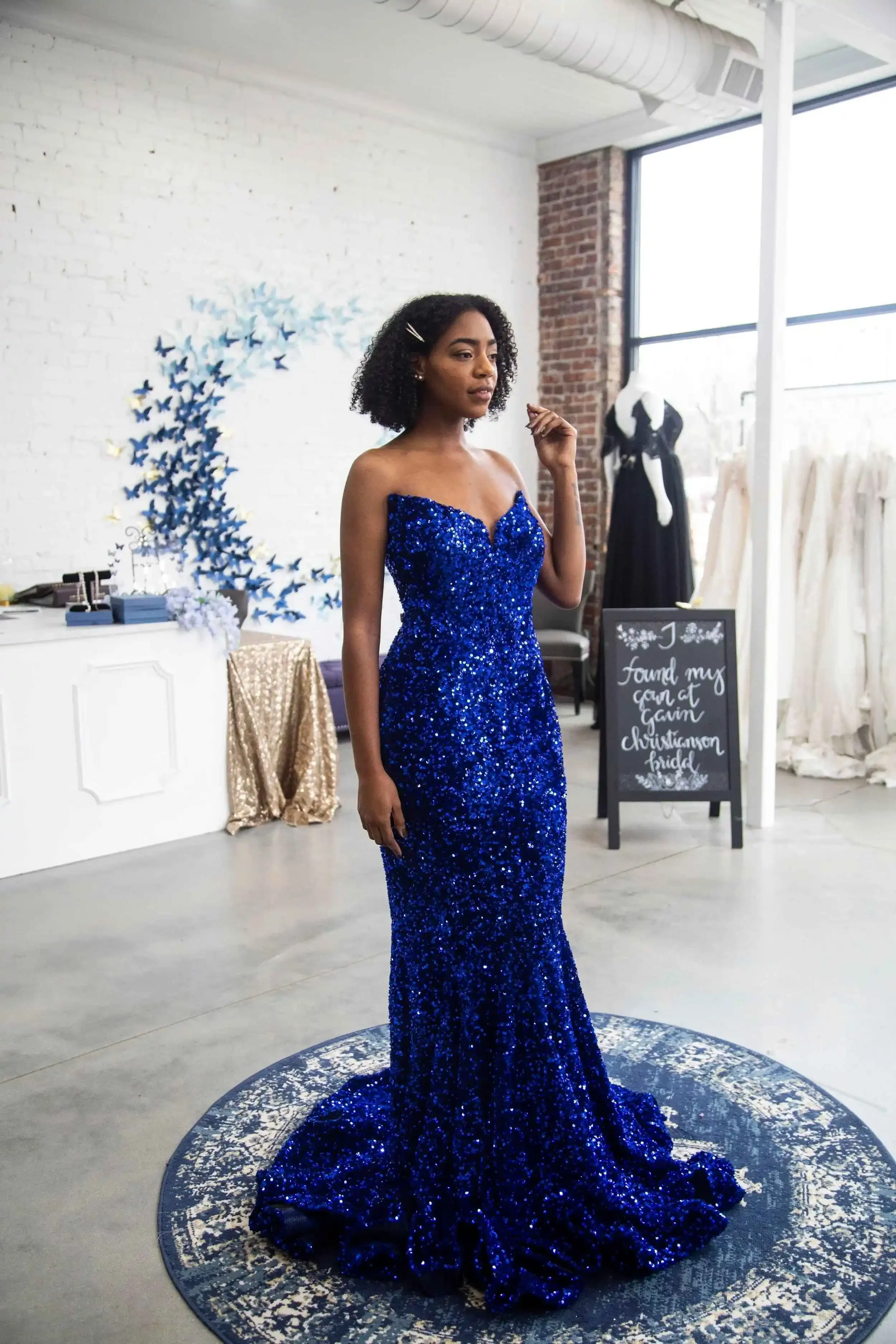 Model wearing a blue sequin strapless evening gown inside Gavin Christianson Bridal showroom