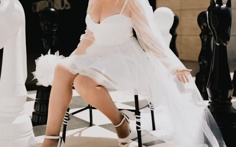 Short tulle wedding dress with sheer sleeves and layered skirt reflecting 2026 wedding dress trends.