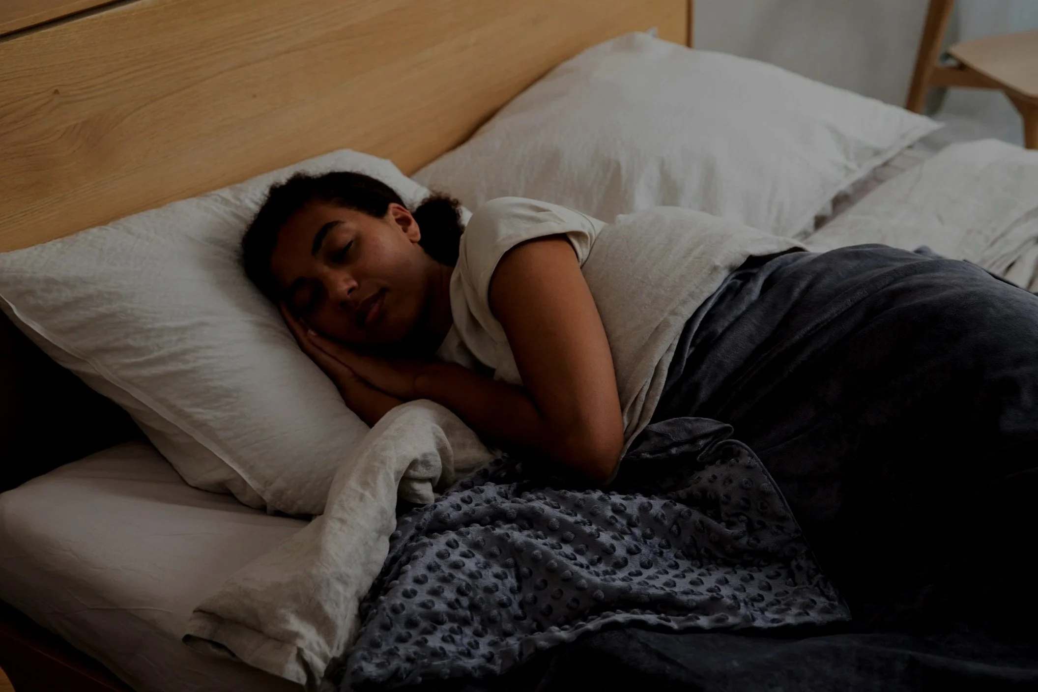 Black woman sleeping peacefully in bed, a reminder that restful sleep in perimenopause is possible