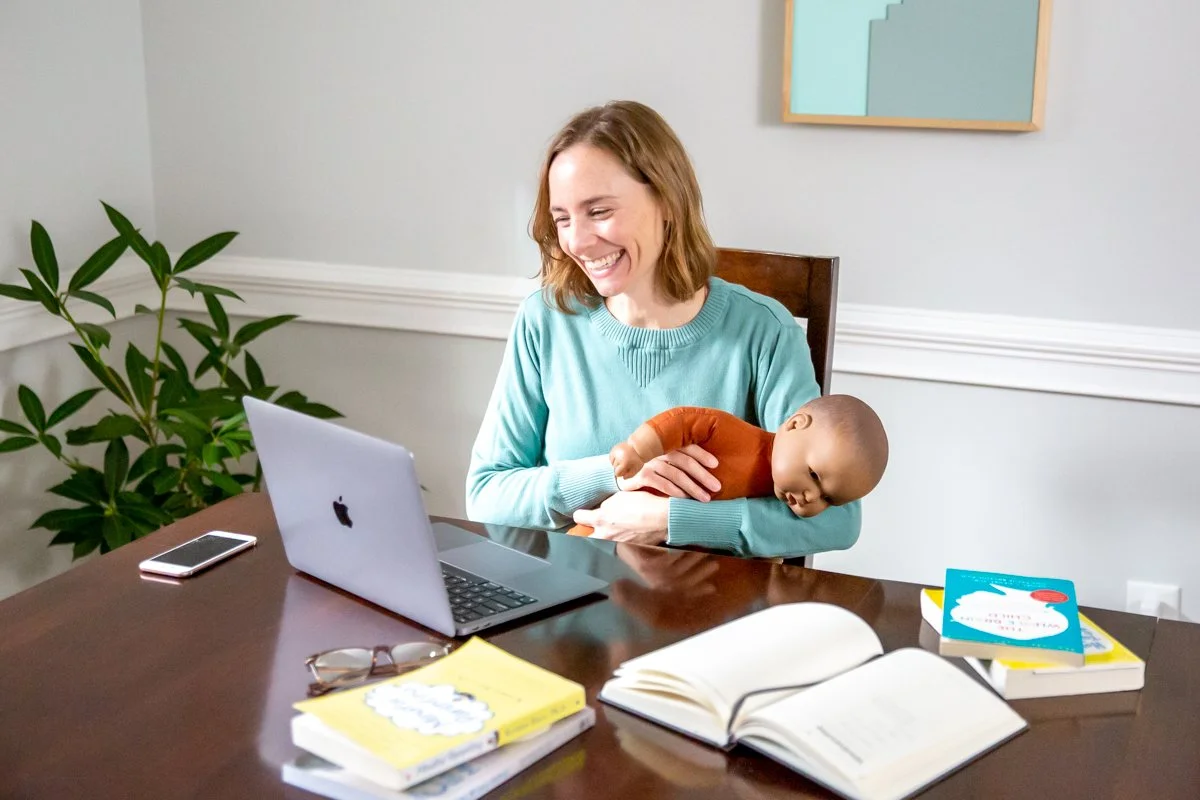 Founder and Lead Sleep Coach, Liz Harden, MPH holding a baby doll while having a sleep coaching session with clients.