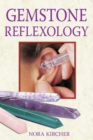Book cover titled "Gemstone Reflexology" by Nora Kircher, featuring an image of a person using a gemstone tool on an ear and various colored gemstone wands at the bottom.