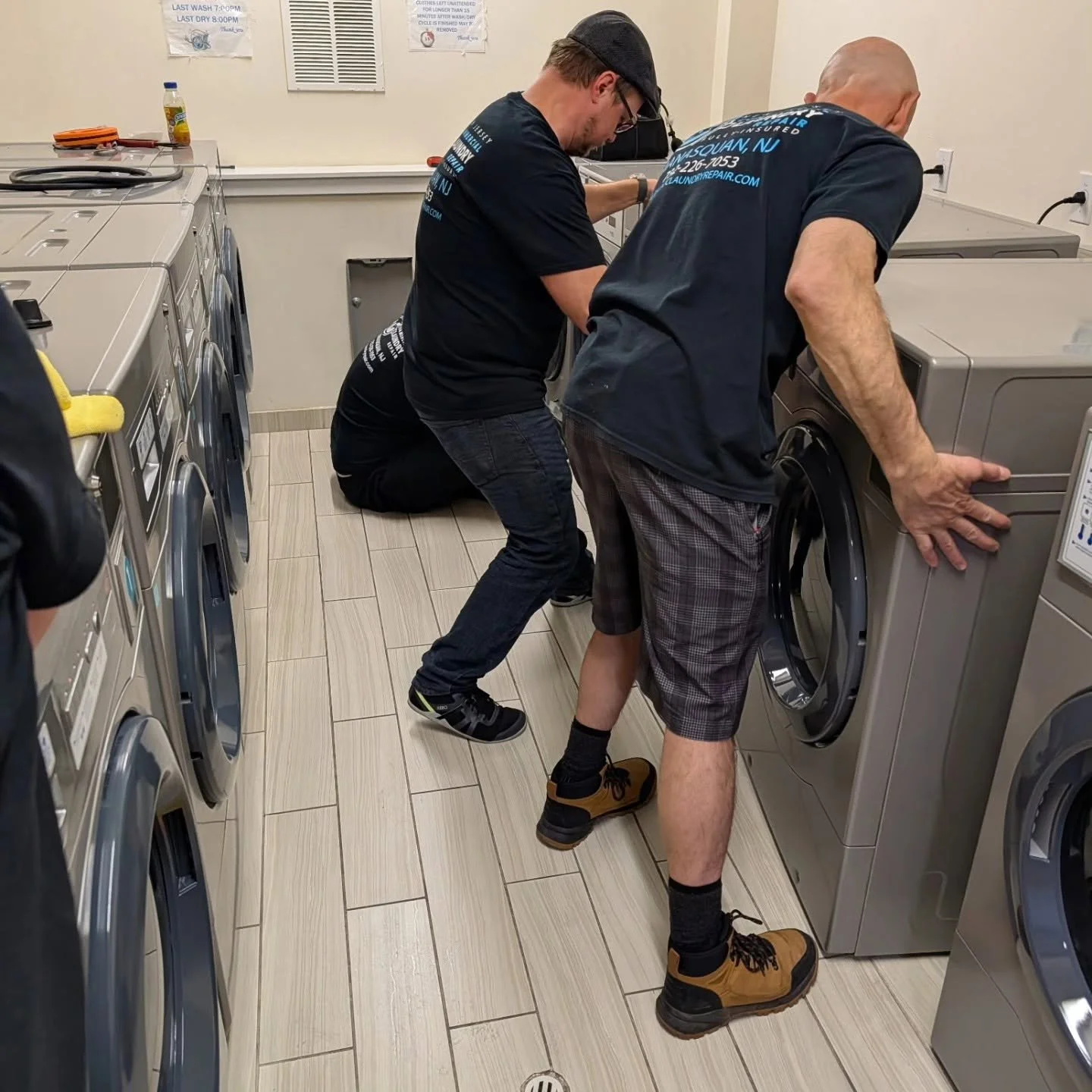 Workers installing commercial laundry equipment