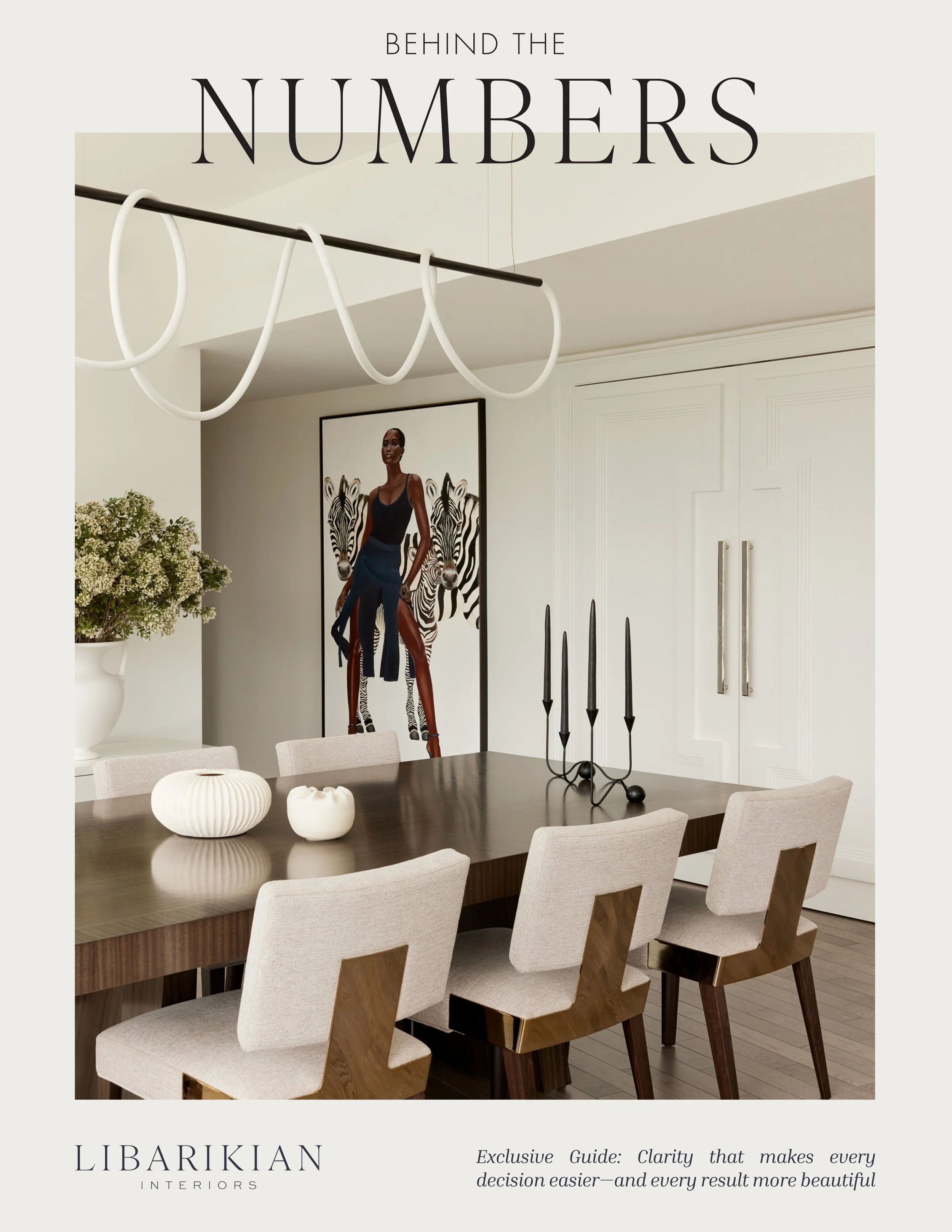 Dining room with a dark wood table, beige upholstered chairs, black candlestick holder, white vases, framed art of a woman and zebras, white cabinets, and decorative lighting fixture.