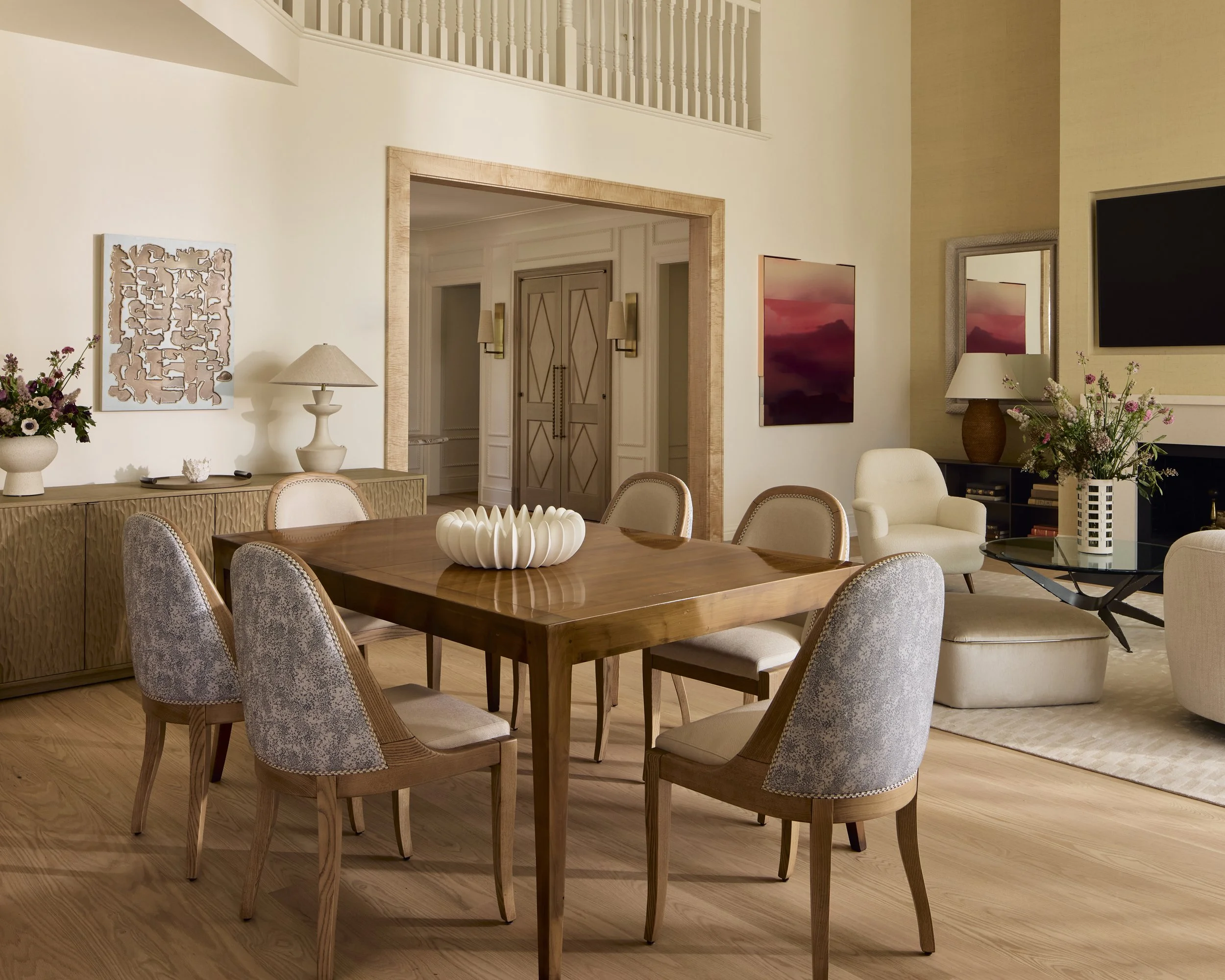 The dining area bridges the open plan layout of the first floor living room. A vintage table is paired with custom made dining chairs, upholstered in fabric that is durable for gatherings and delicate enough to feel sophisticated.
