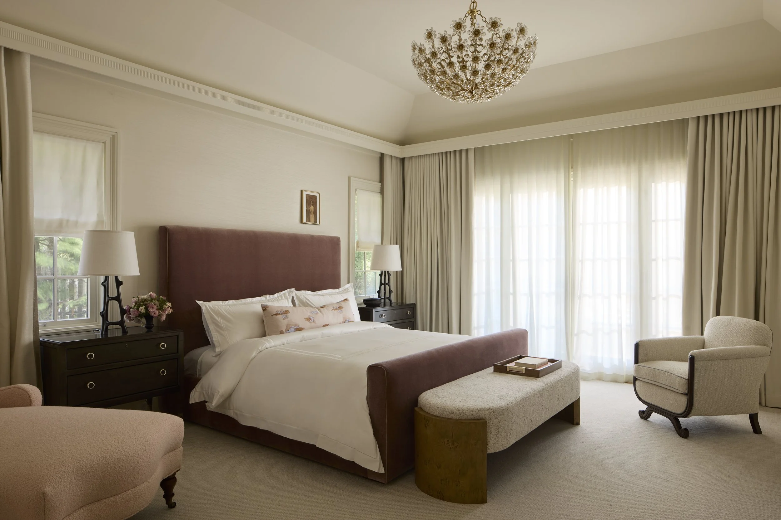 The primary bedroom is a serene oasis featuring a soft cream and rose color palette.