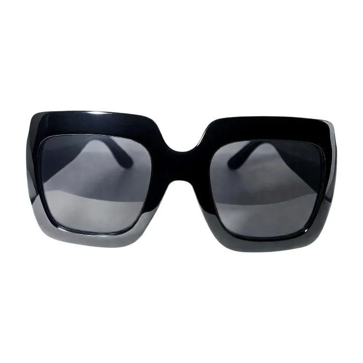 Black oversized sunglasses with dark lenses on a white background.