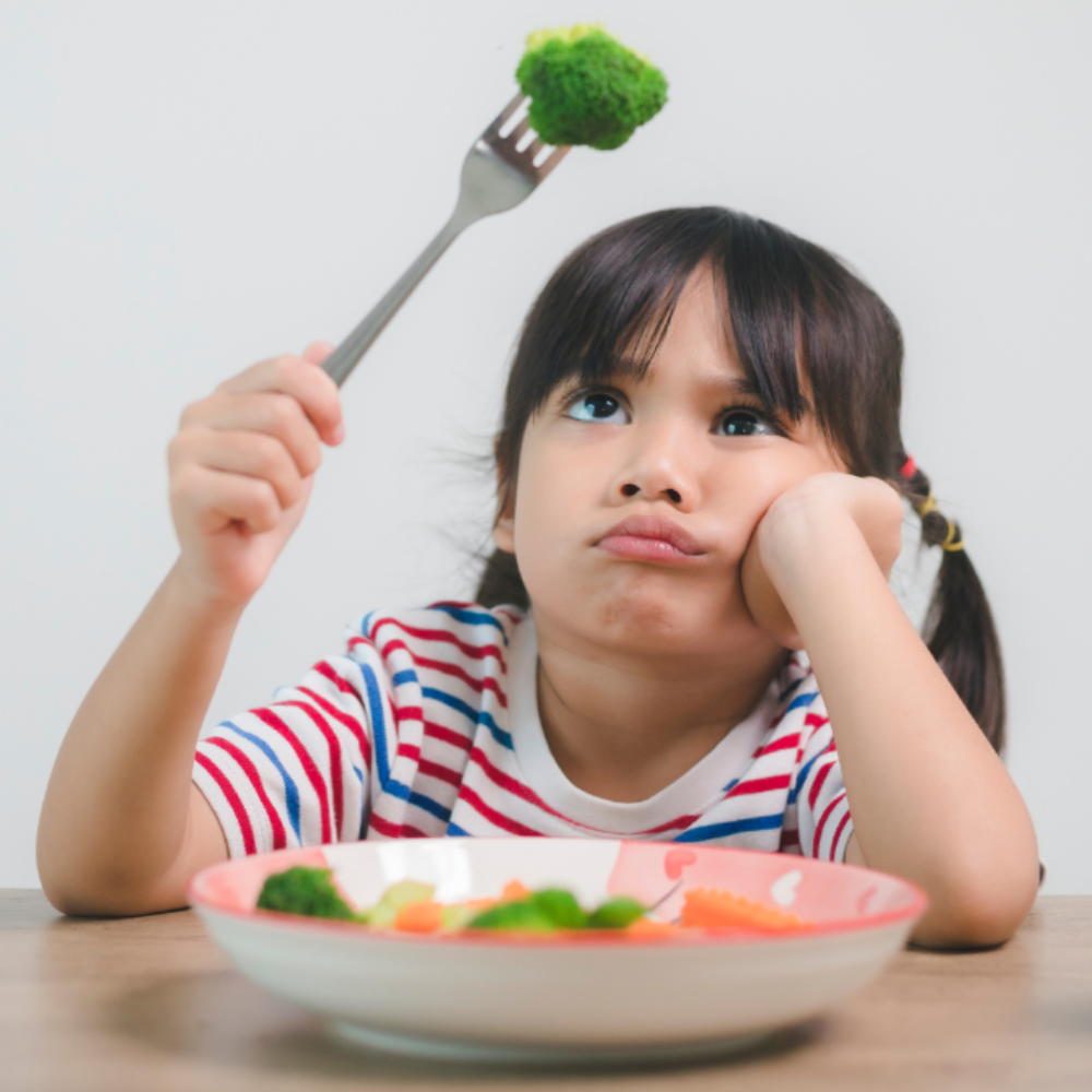 young girl being a picky eater with broccoli on a fork