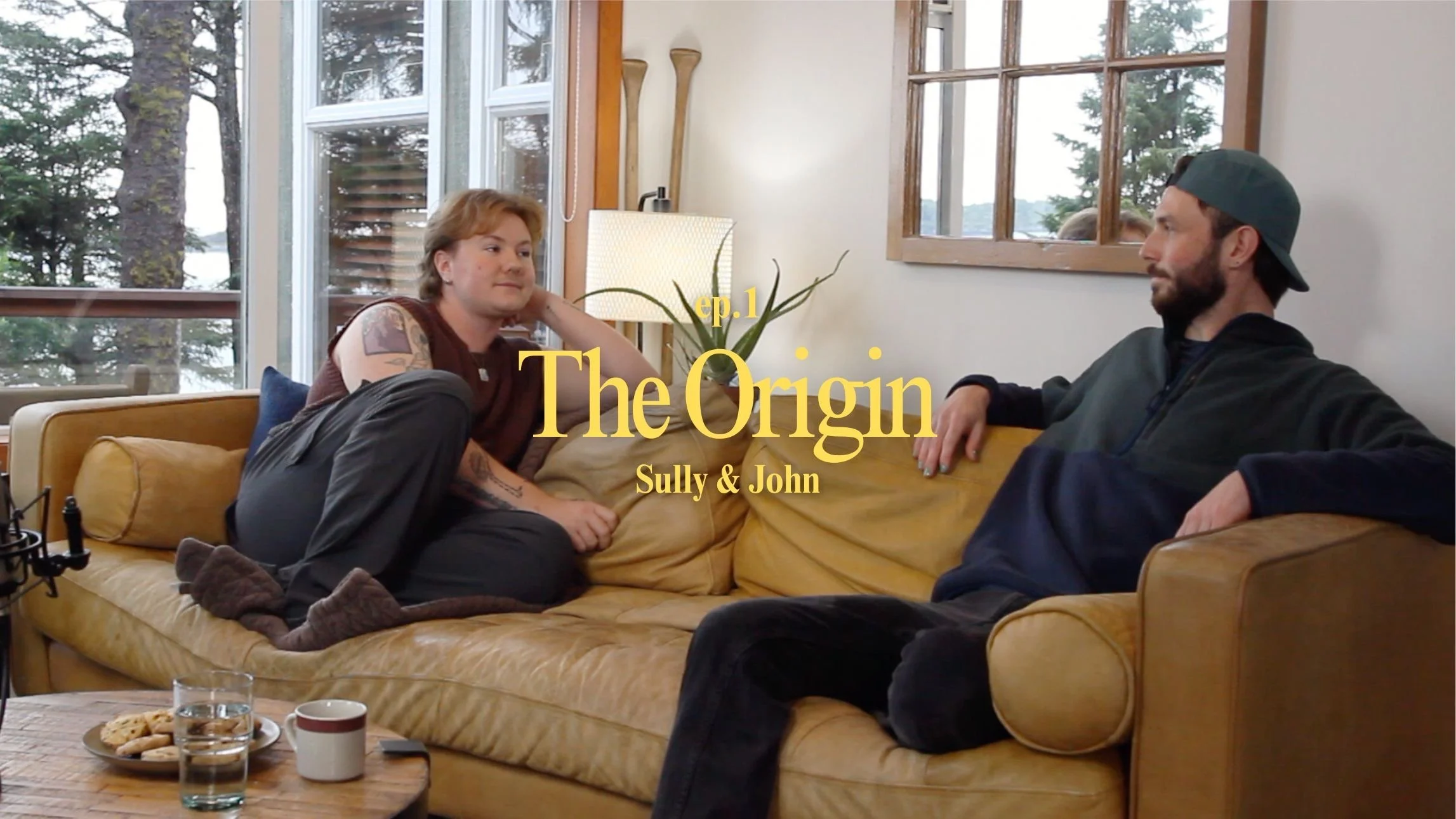 Sully and John sitting on a couch. The title 'The Origin'.