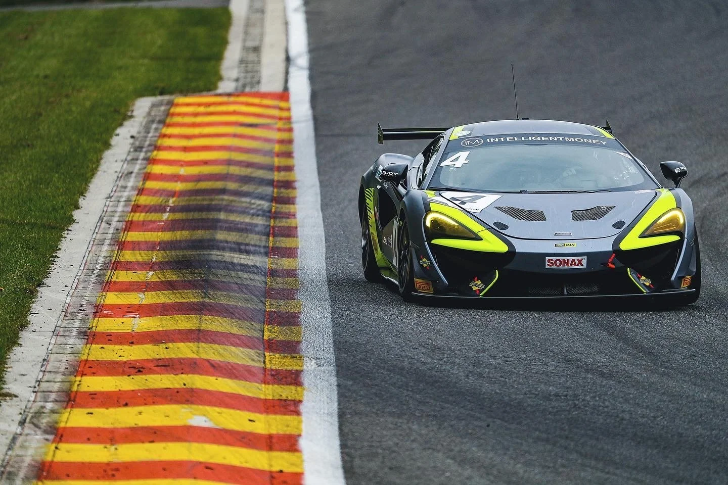 Race car on track with colorful curbs, Spa-Francorchamps circuit