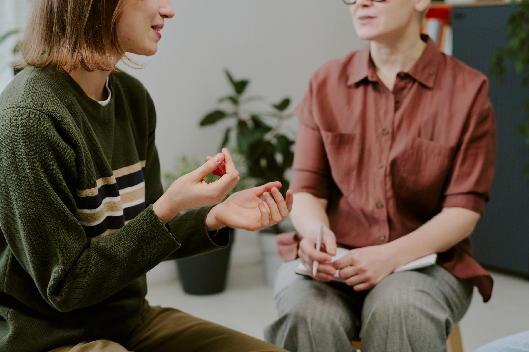 A patient chats with her therapist, talking with her hands.