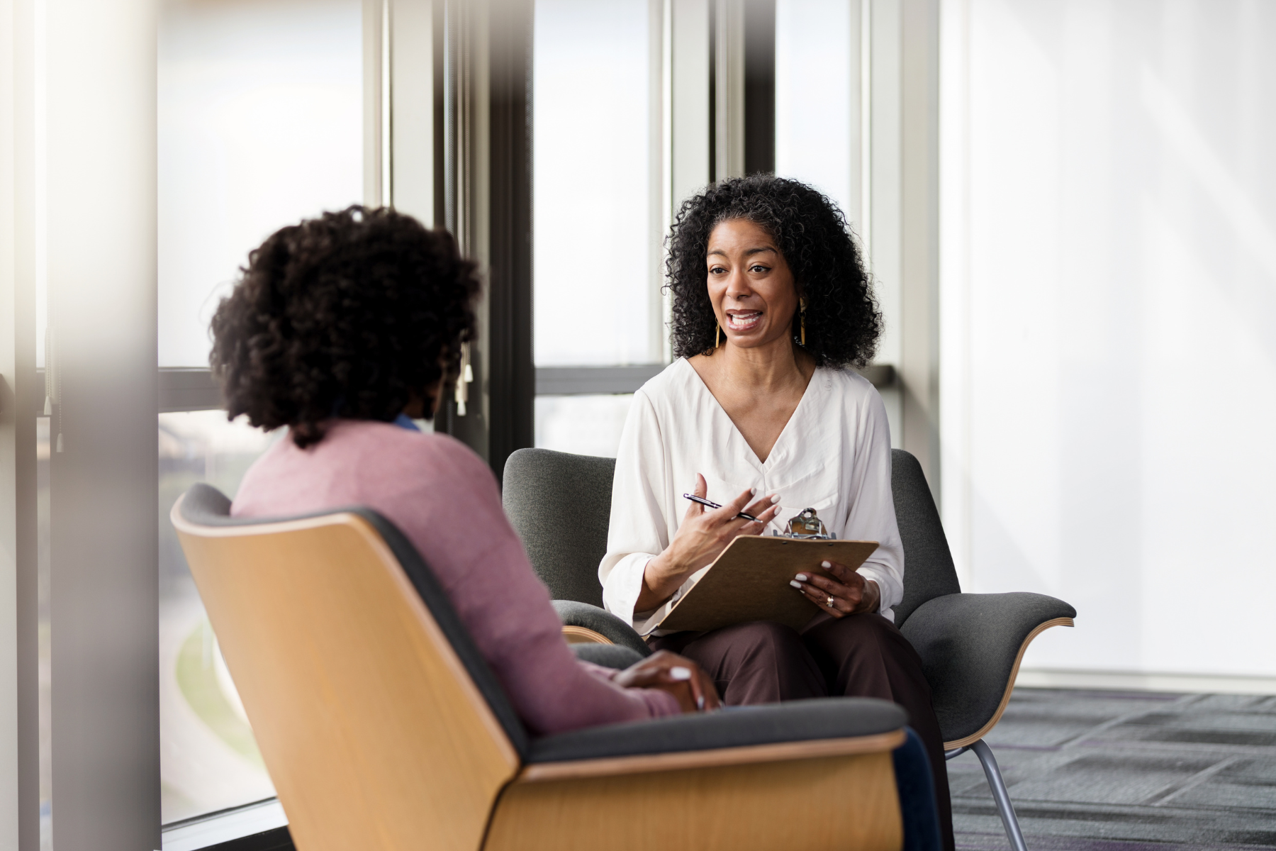 A therapist and her patient sit across from each other, talking.