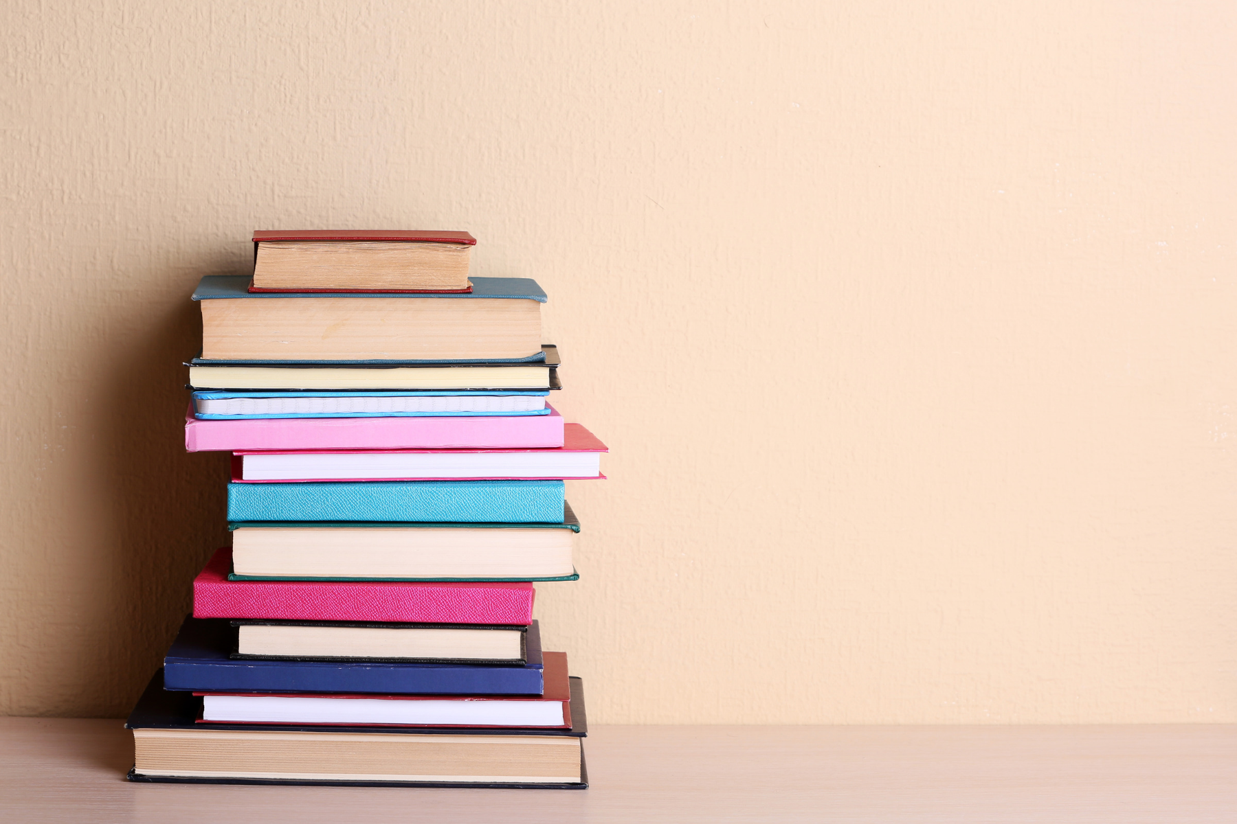 A stack of books against a tan background.
