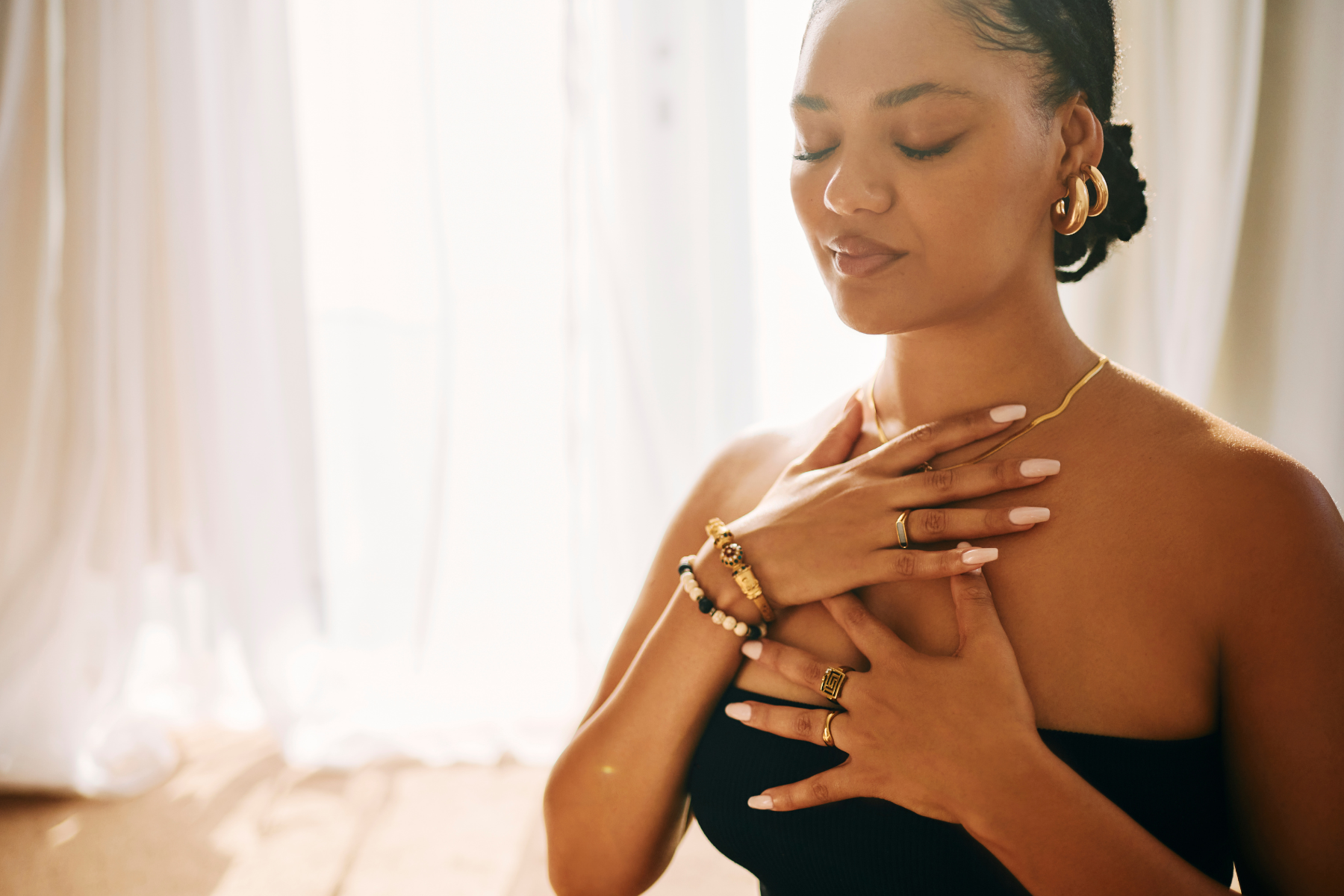 A woman holds both hands against her chest, regulating her breath