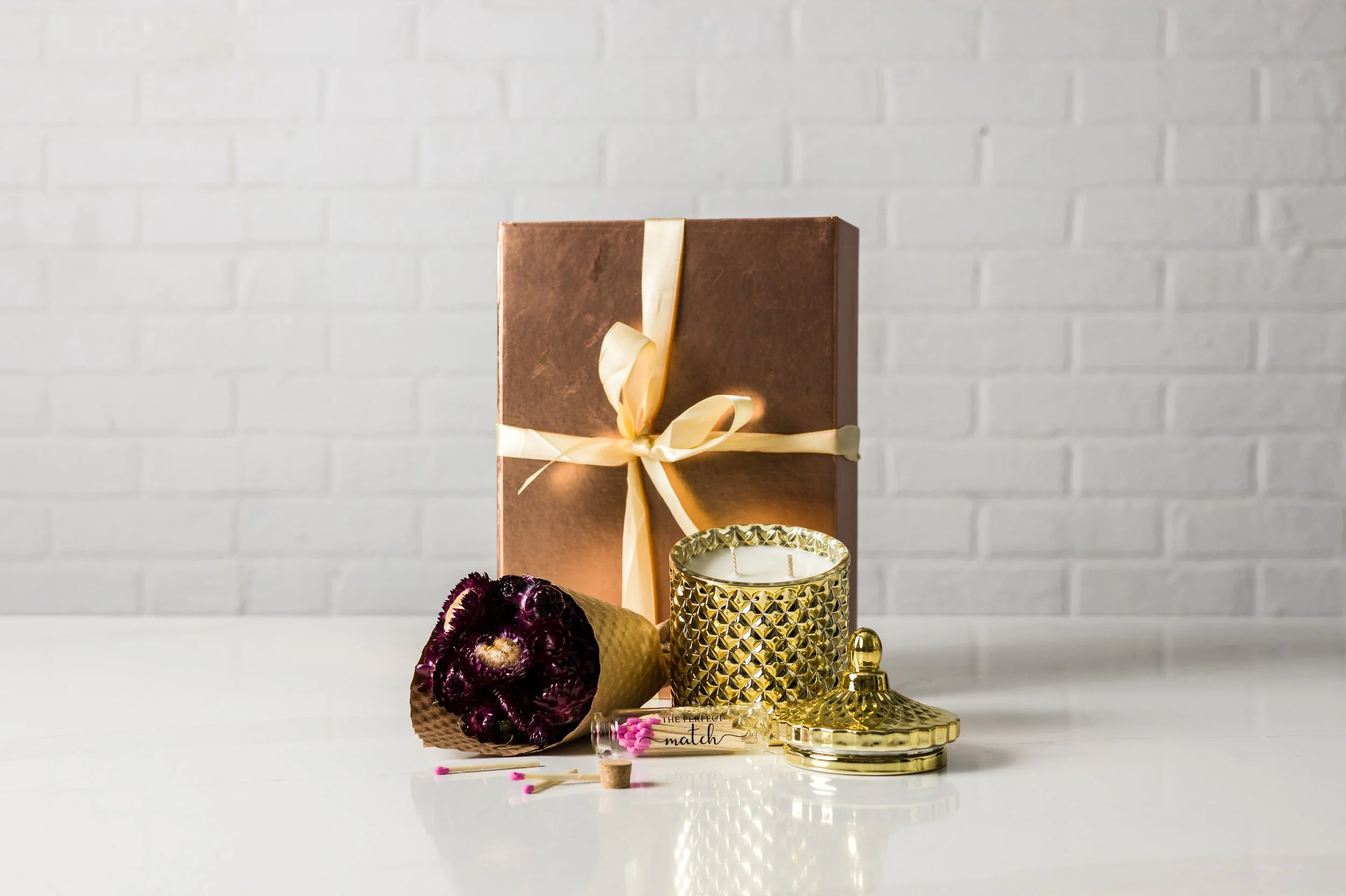 Luxury gold two-wick soy candle gift box with dried strawflower bouquet and matches in a glass jar
