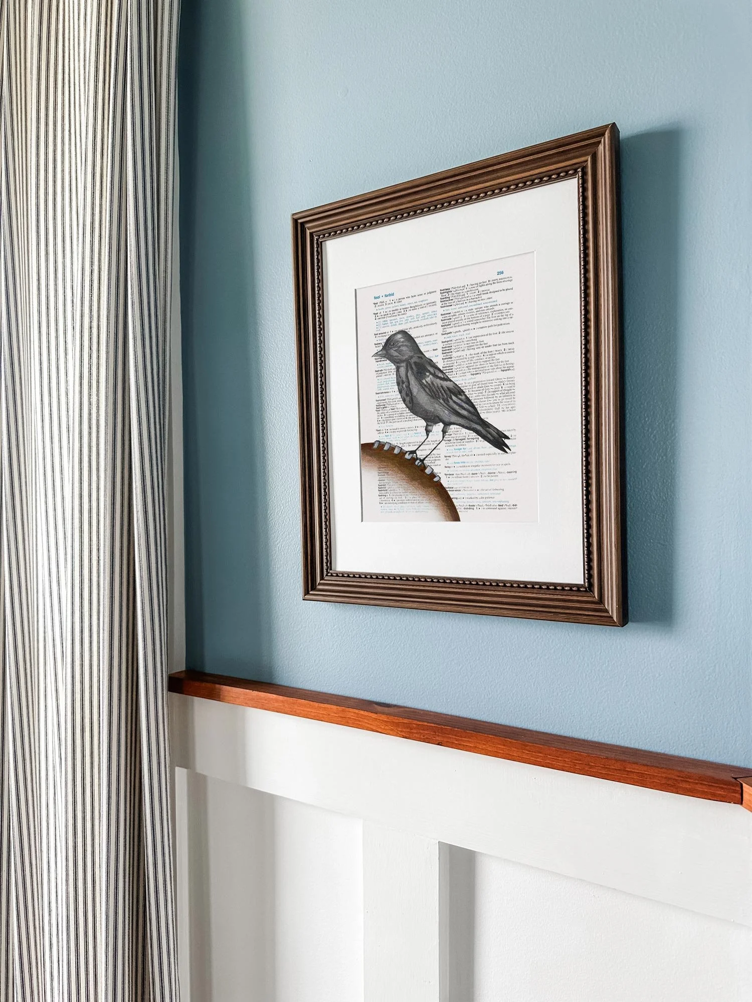 Dictionary fine art print of a black raven bird sitting on a football representing the Baltimore Ravens.