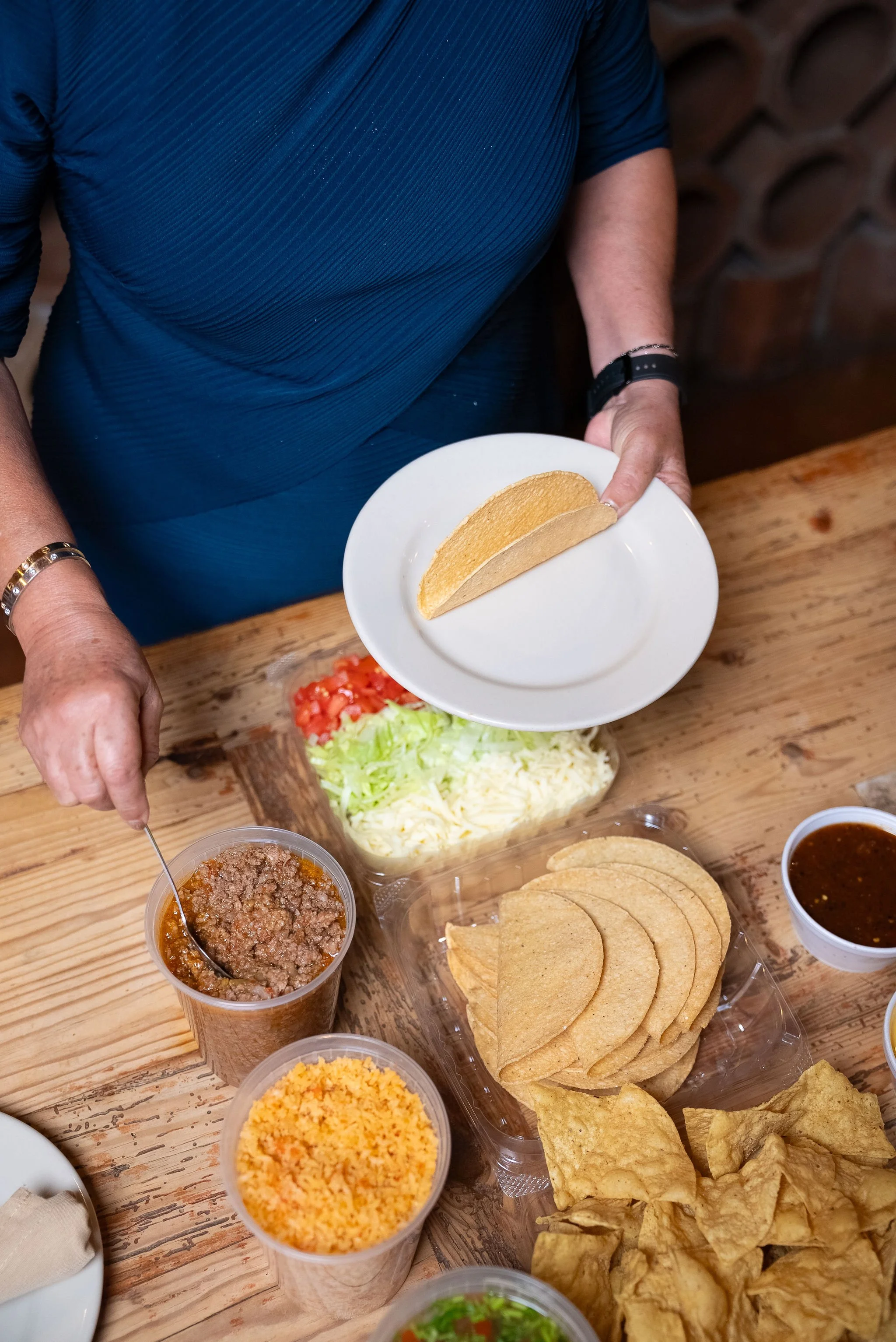 Serving a crispy taco from an Aldaco's Taco Kit to-go at the family table