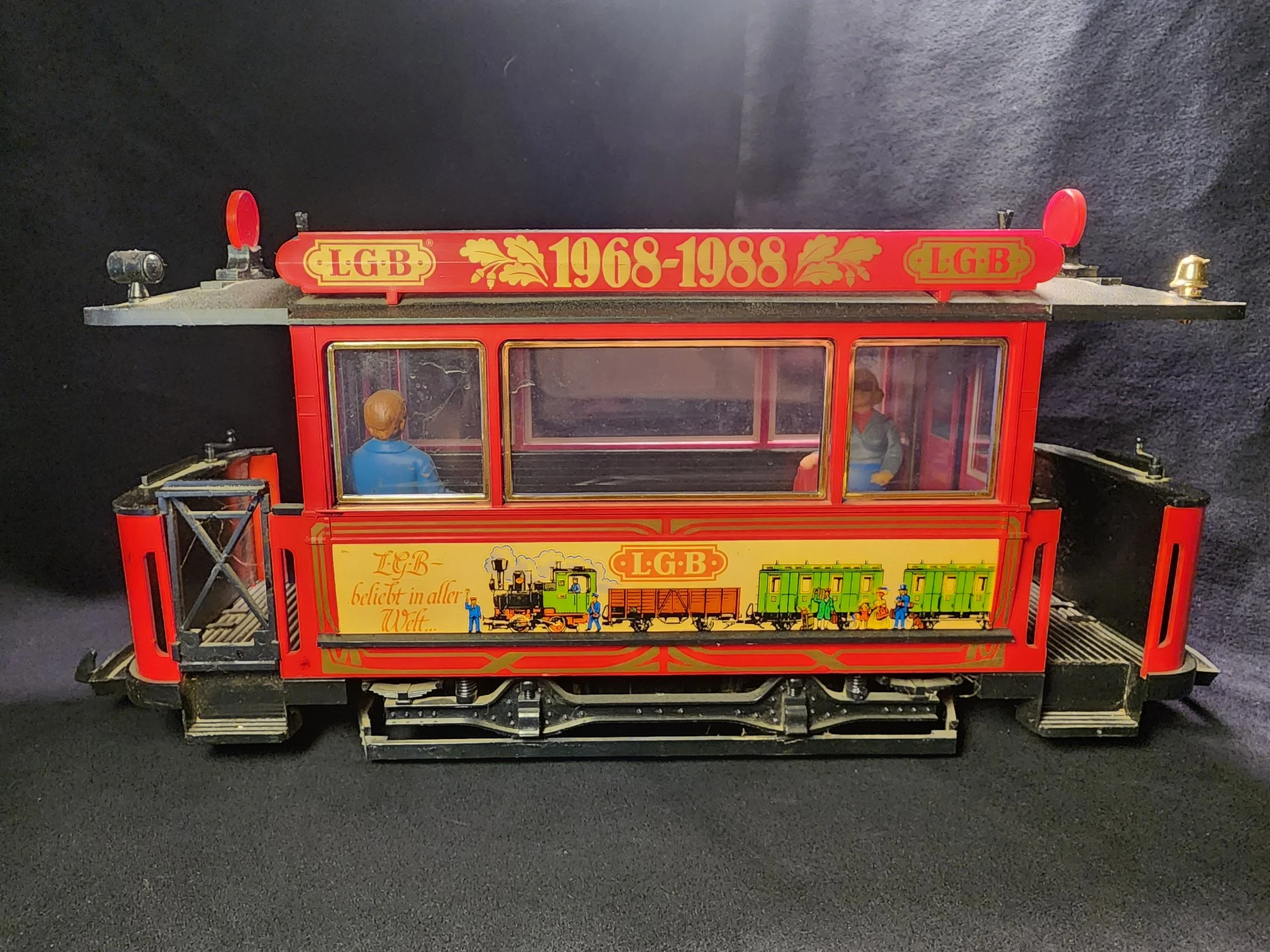 Toy model of a red train station with figures and a locomotive.