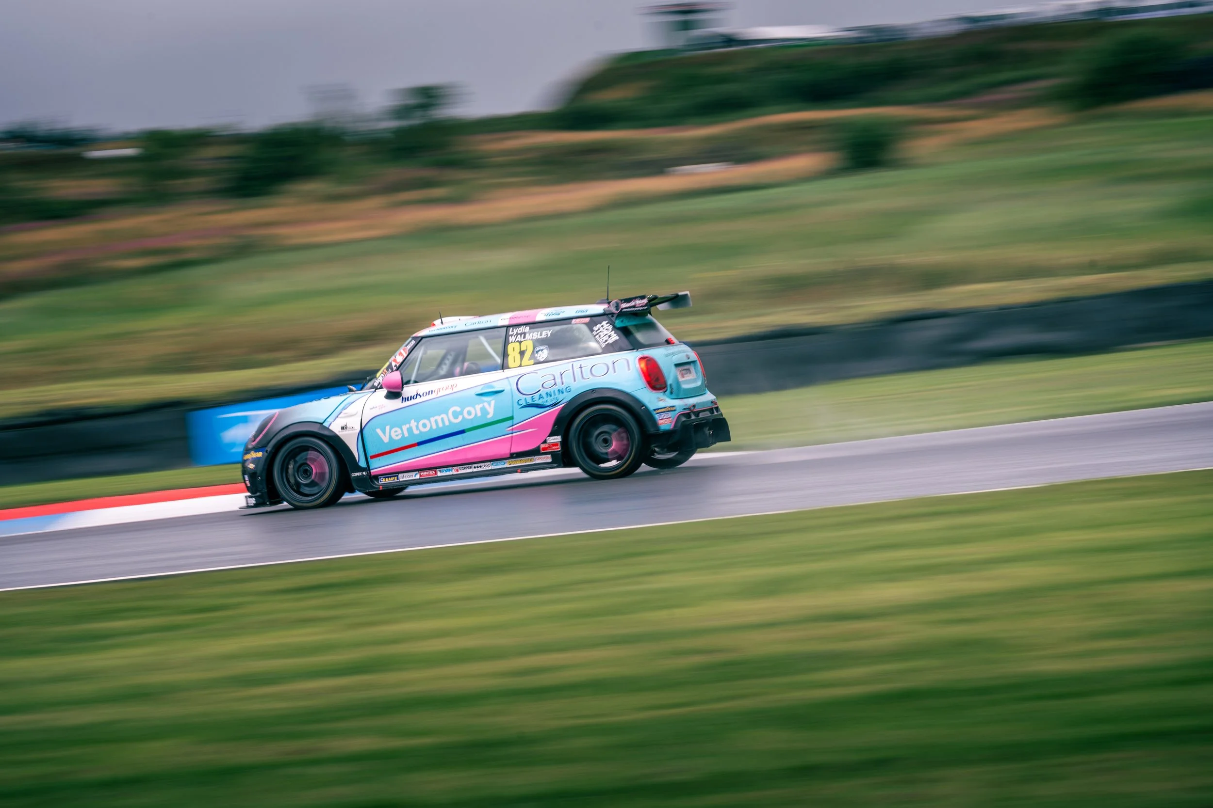 Race car driving on a wet race track with motion blur in the background