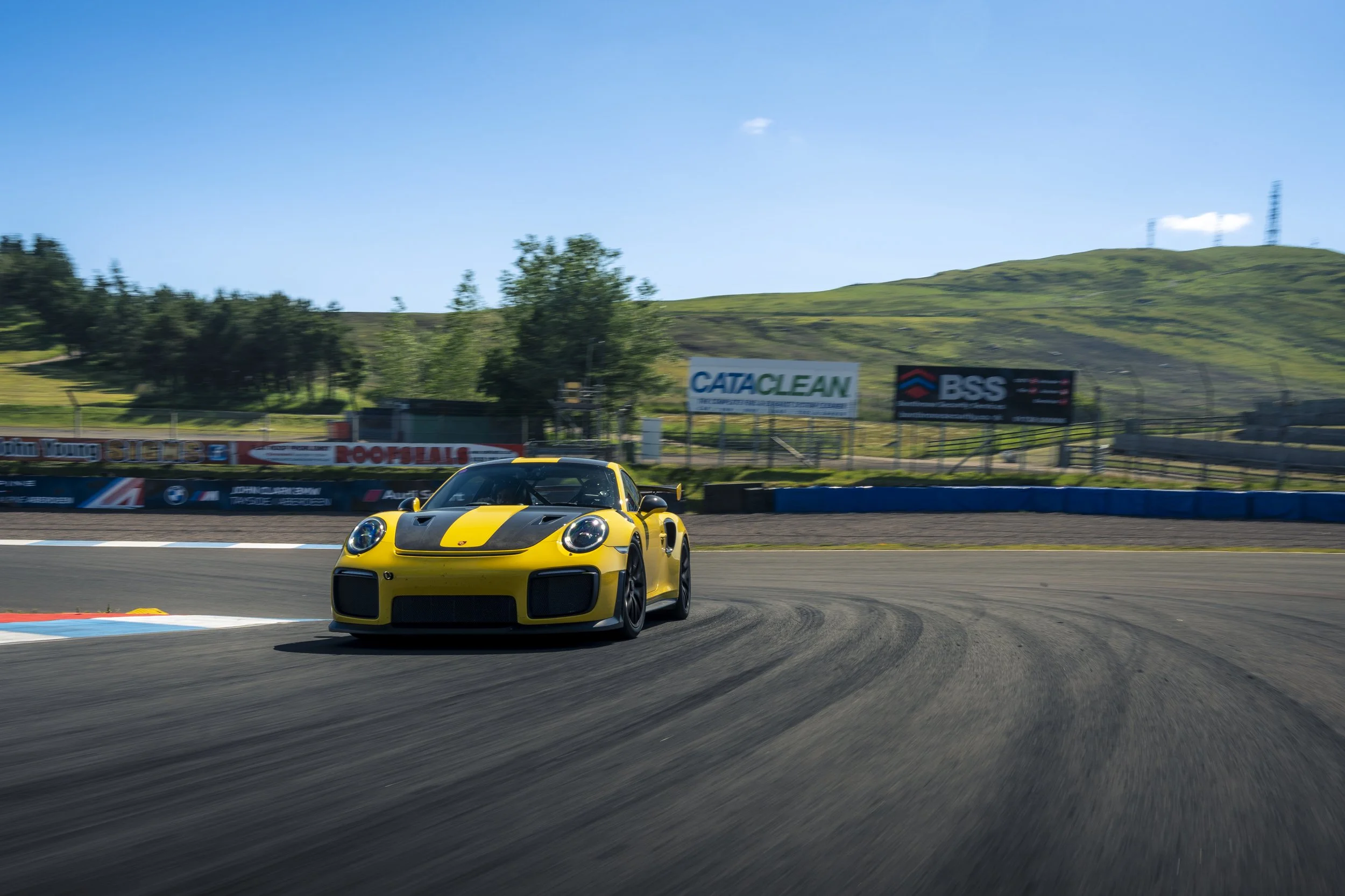 Porsche GT2RS Yellow race car on a track during daytime