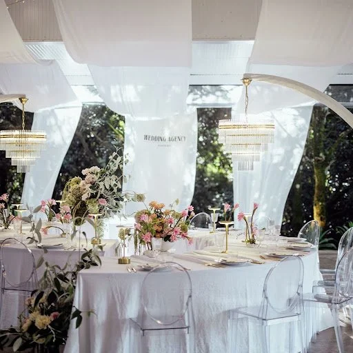 Wedding venue with outdoor ceremony spaces and elegant indoor reception areas featuring floral table settings.