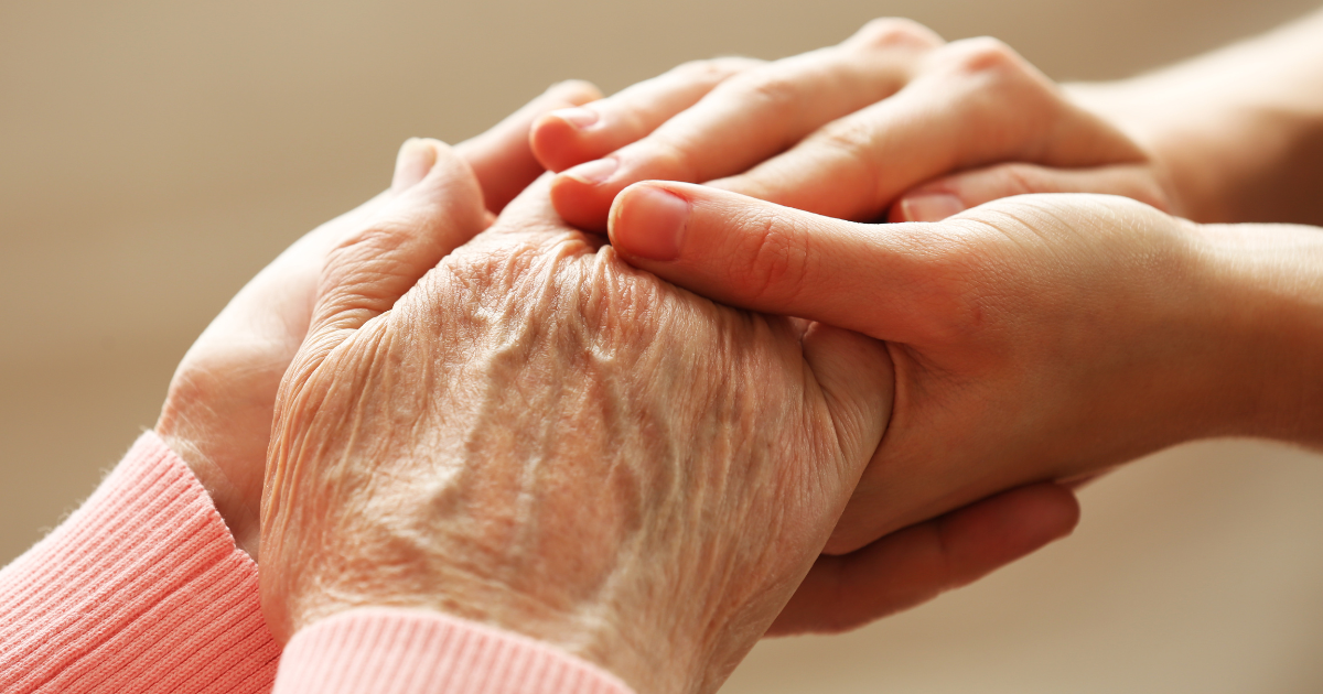 Different aged hands clasped together.