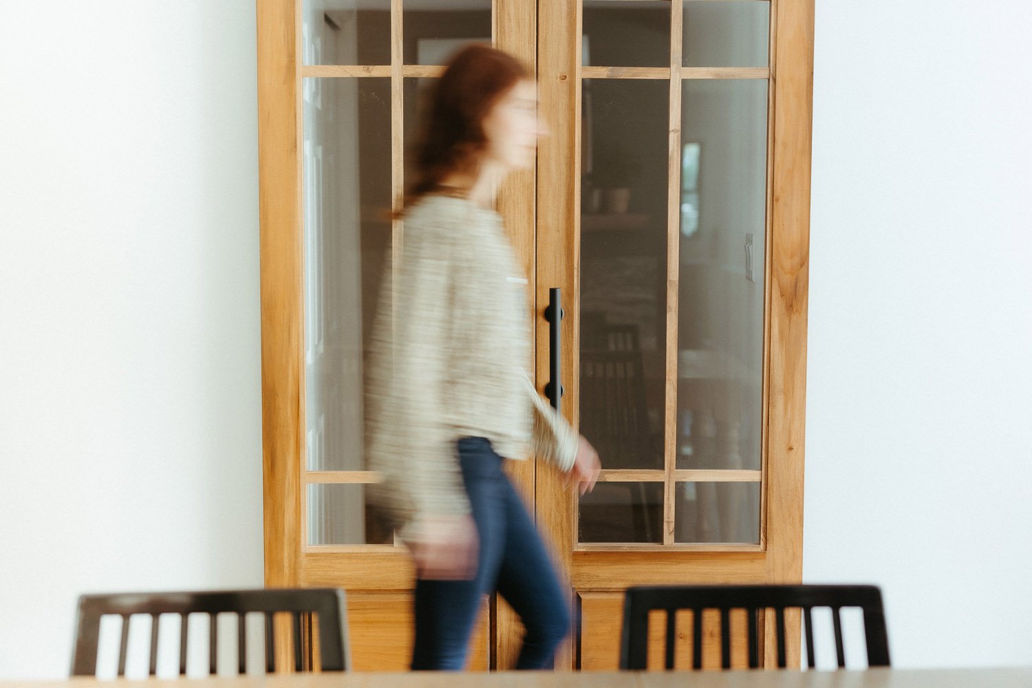 blurred-brunette-woman-walking-past-wooden-doors-branding-photographer-autumn-skye.jpg
