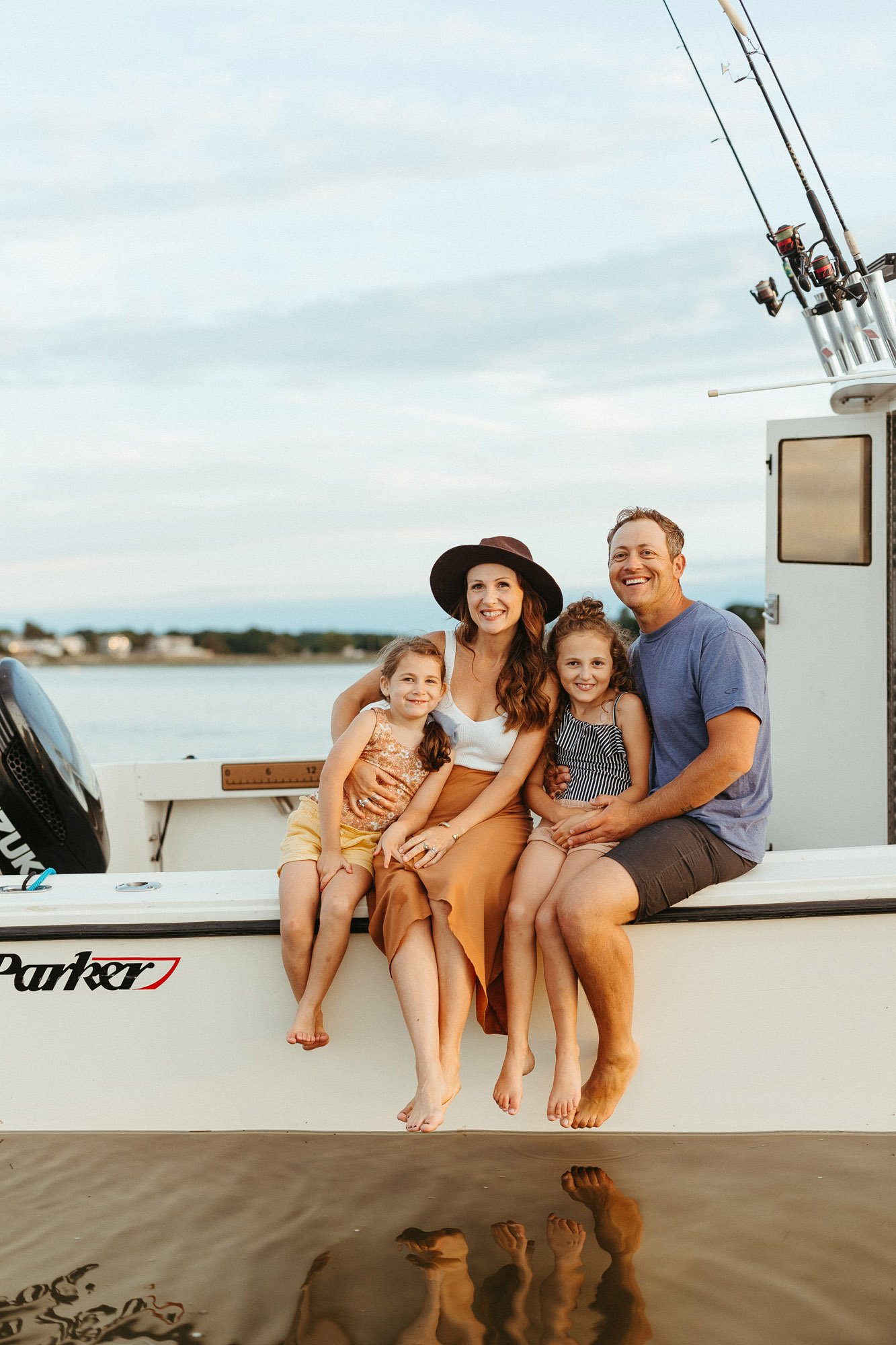 parents-two-daughters-sat-on-side-of-boat-family-photographer-autumn-skye.jpg