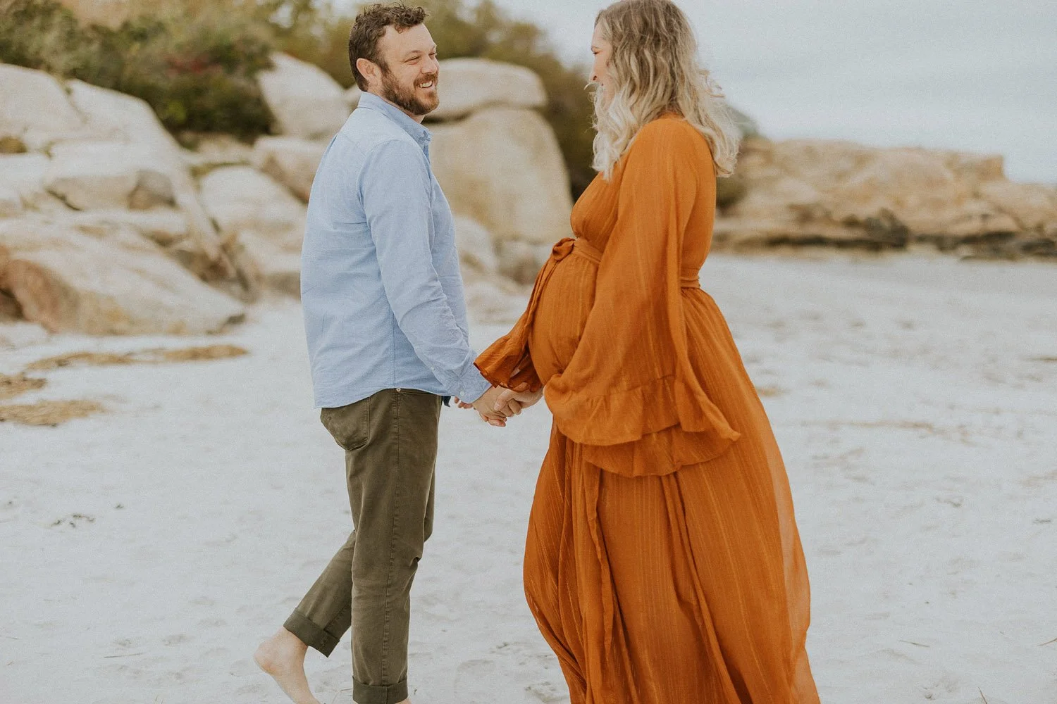 parents-to-be-holding-hands-on-beach-family-photographer-autumn-skye.jpg