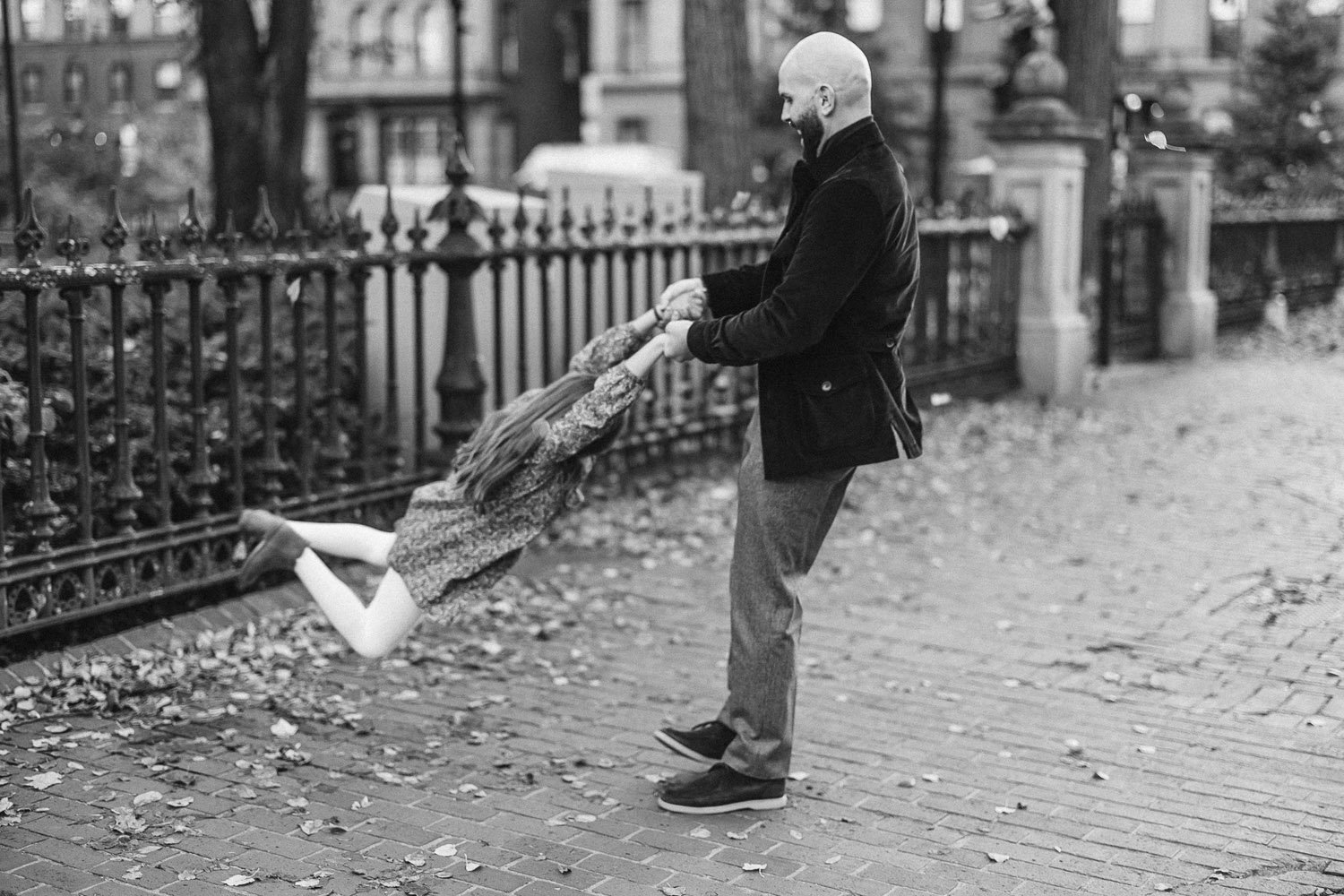 dad-swinging-daughter-in-air-fall-monochrome-family-photographer-autumn-skye.jpg