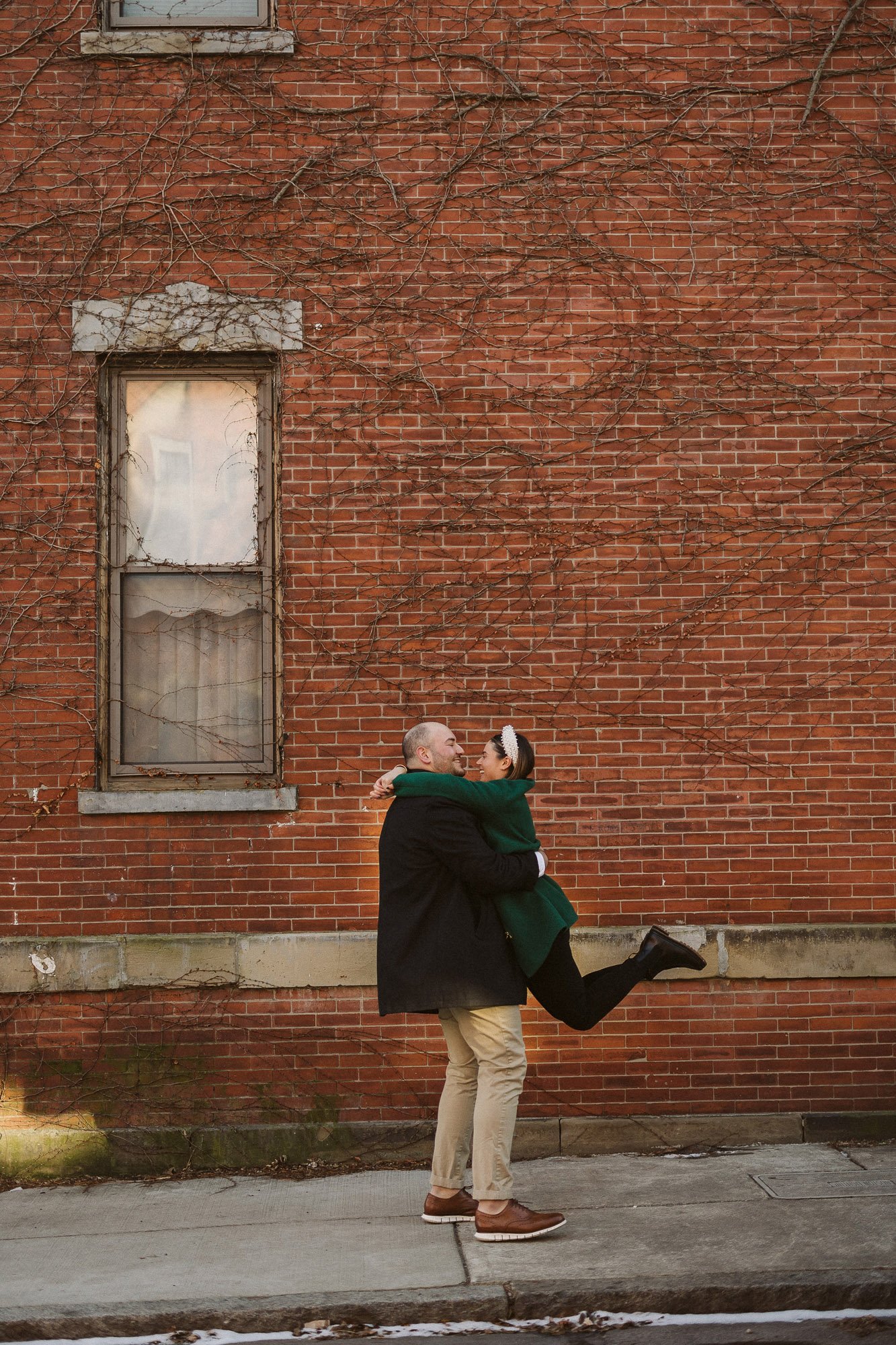 man-lifting-woman in-air-against-brick-wall-couples-photographer-autumn-skye-phoenix-boston.jpg