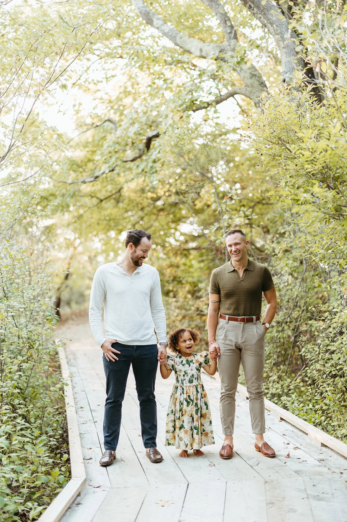 dad-sholding-daughters-hands-wooded-boardwalk-autumn-skye.jpg