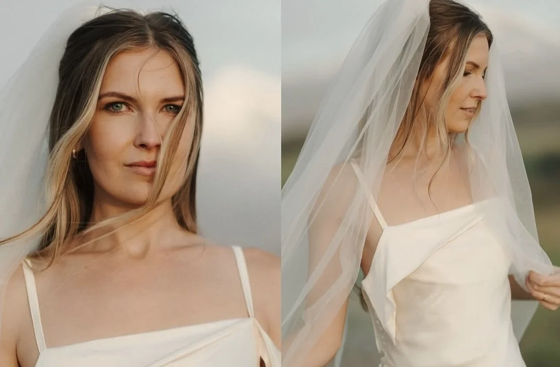A woman with long blonde hair, wearing a white dress and a wedding veil, outdoors in natural light.