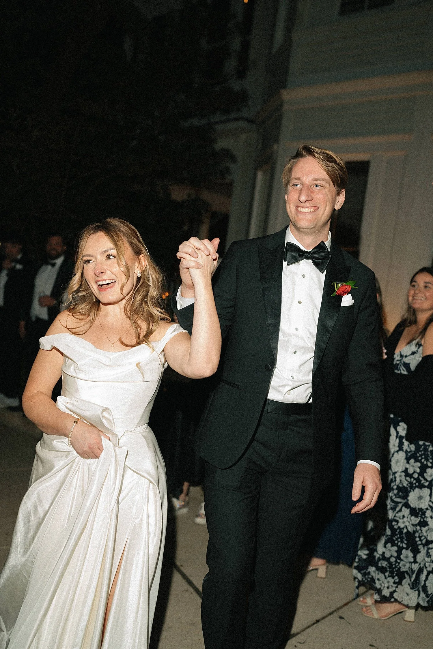  newlyweds raise their hands in celebration during exit by Austin wedding photographer 