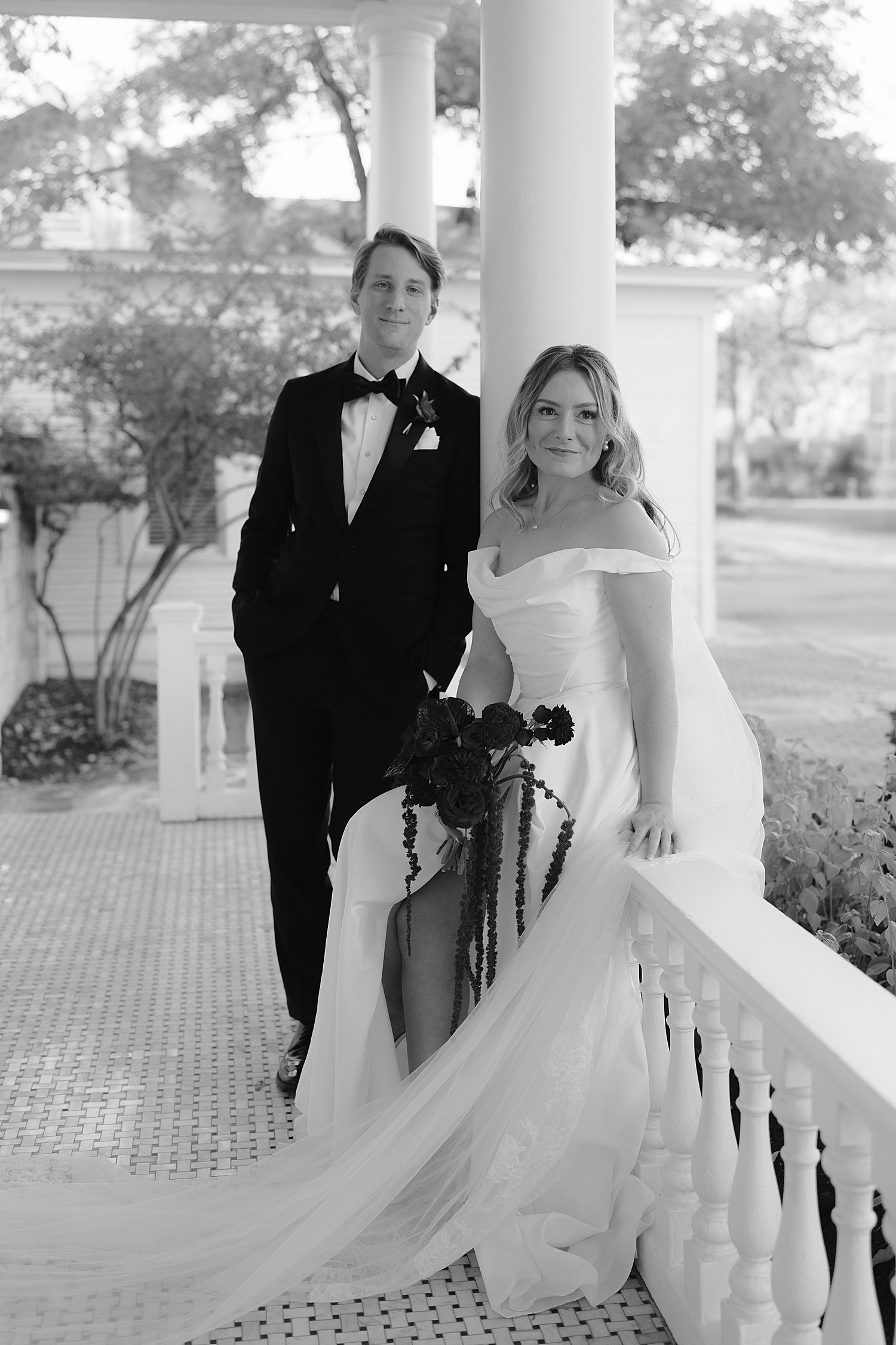  newlyweds sit on balcony ledge at historic home by Jessica Joseph Photography 