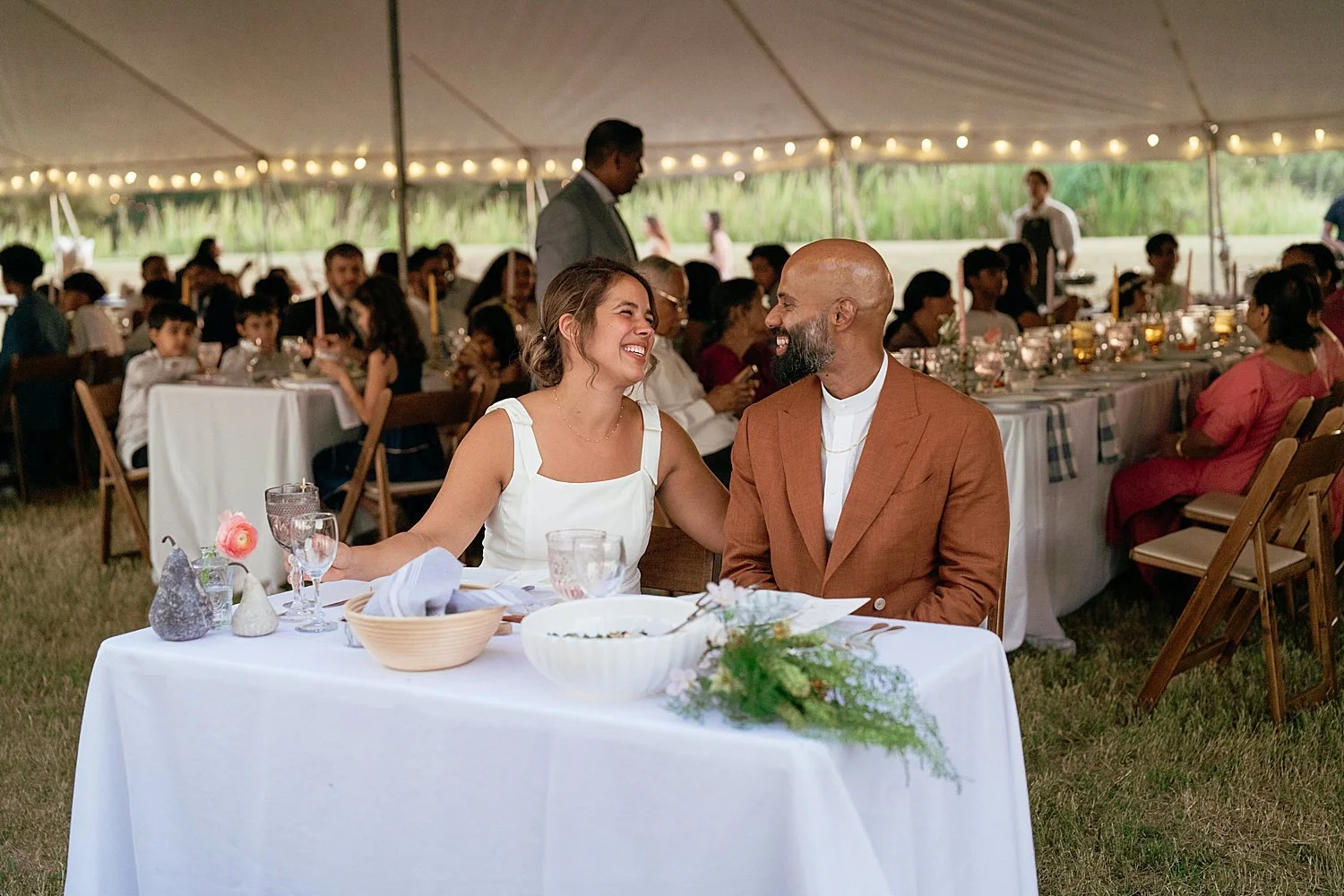  bride and groom sit down to enjoy a dinner at the table by Austin wedding photographer 