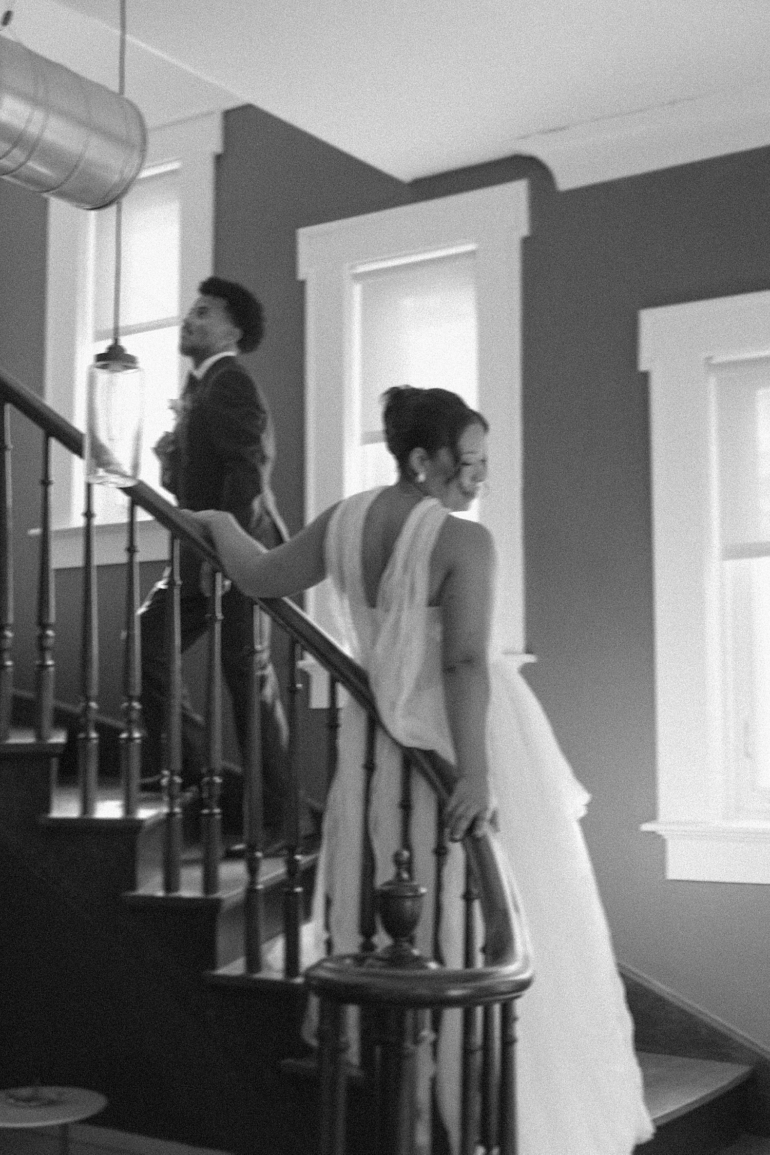  man and woman stand on stairs at The Caroline before walking down aisle 