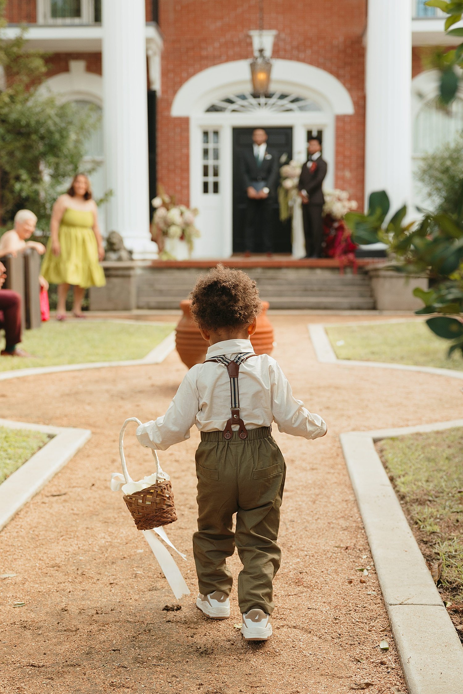  toddler walks down gravel pathway aisle as ring bearer at The Caroline 