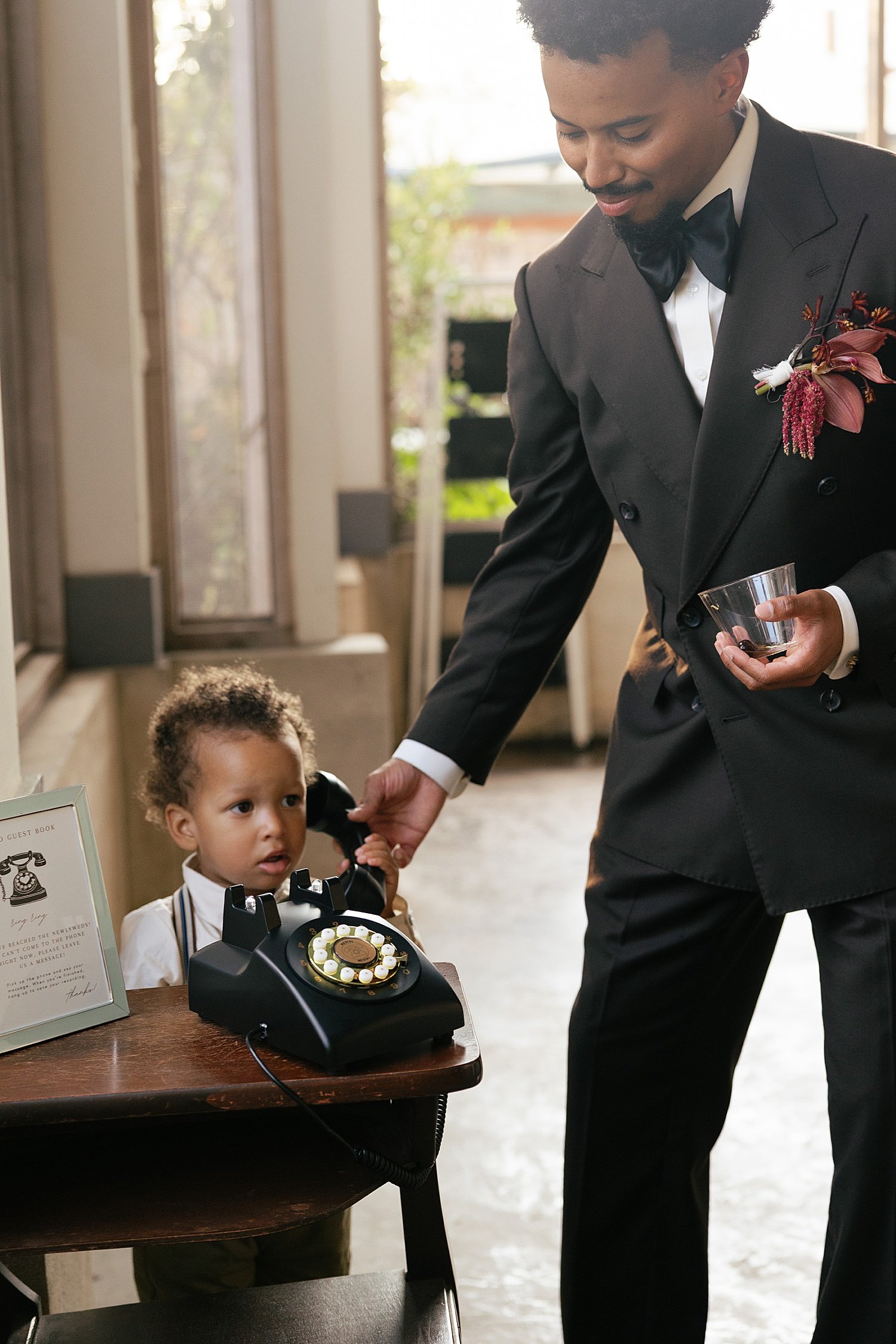  groom helps his toddler nephew at reception by Austin wedding photographer 