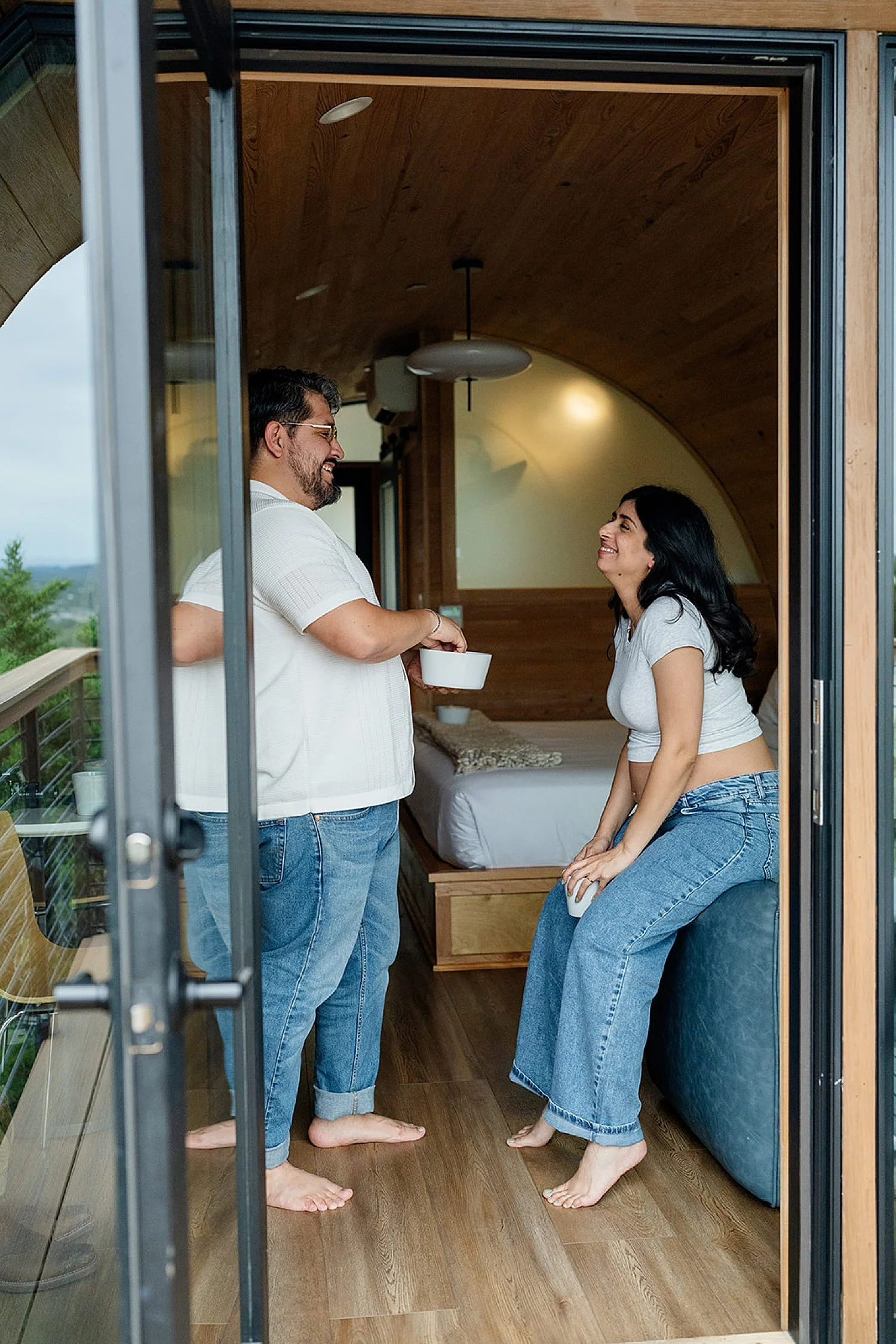  couple sits at Onera in Wimberley Texas room for their babymoon photo session 